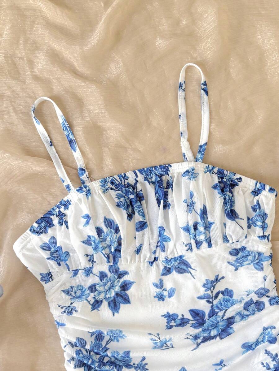Tween girl yellow mini sundress with large pink floral hibiscus print, spaghetti straps, high waist, flared hem, and sleeveless cami style for summer beach wear
