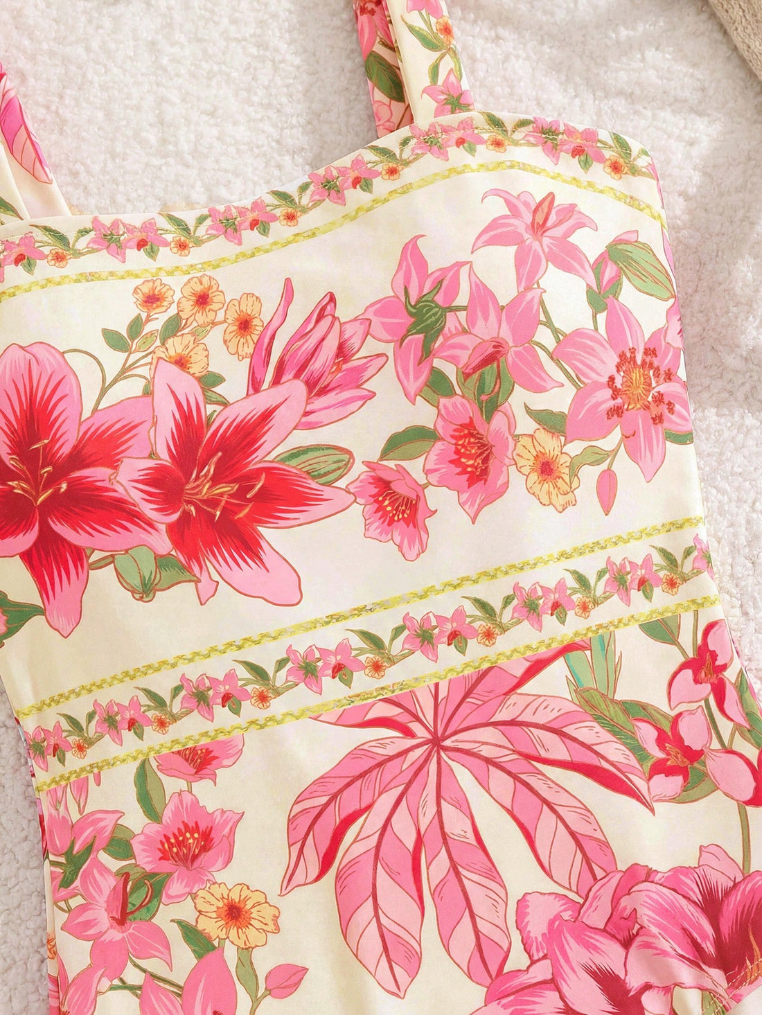 Tween girl floral print one-piece swimsuit with twist front, spaghetti straps, fitted shape, and multicolor all-over hibiscus-inspired pattern for beach and pool wear.