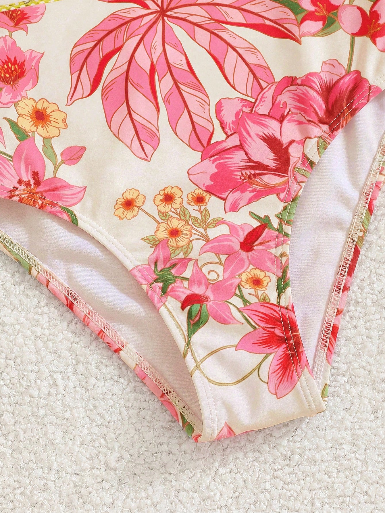 Tween girl floral print one-piece swimsuit with twist front, spaghetti straps, fitted shape, and multicolor all-over hibiscus-inspired pattern for beach and pool wear.