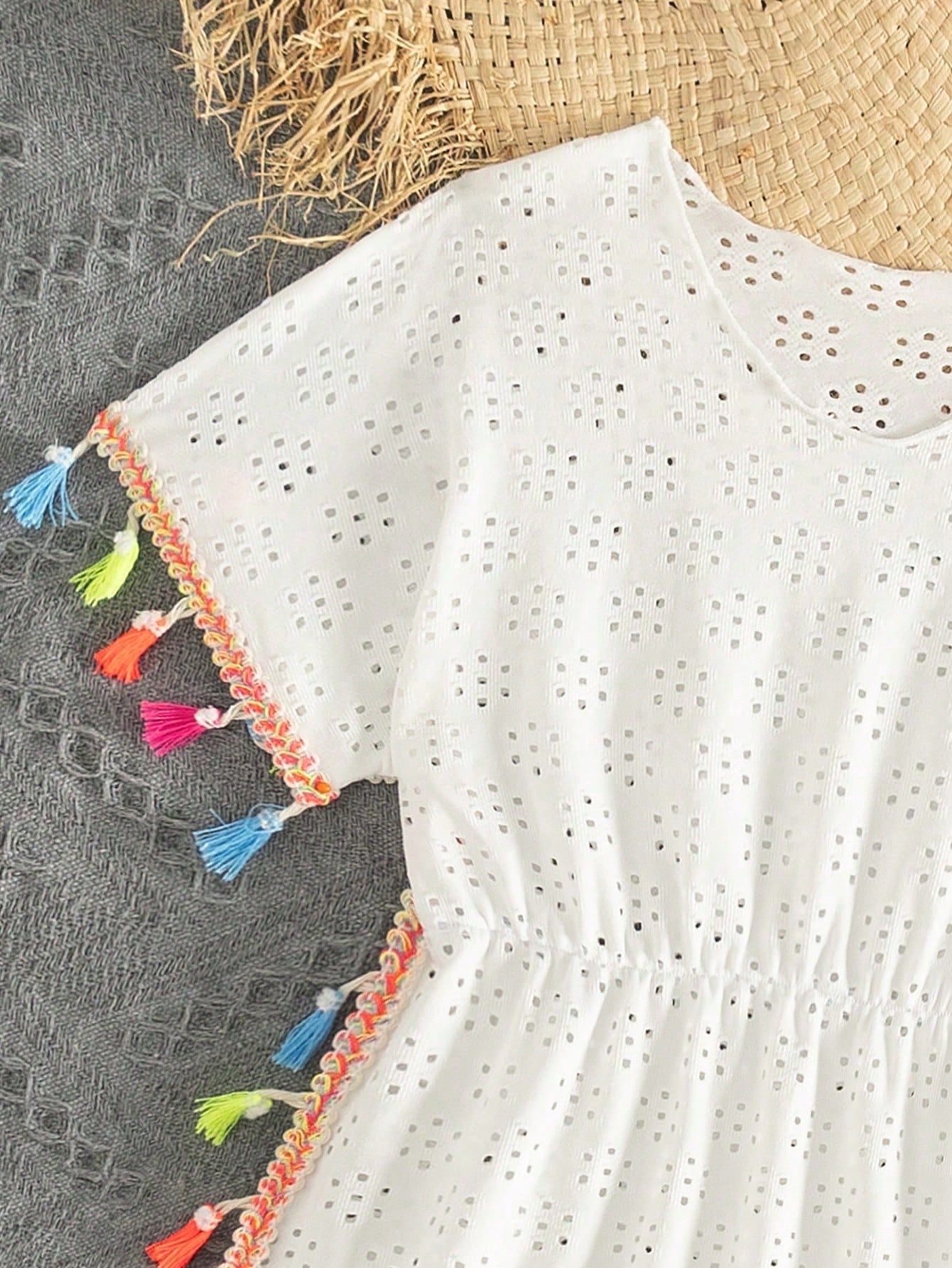 Tween girl white swimsuit cover up with colorful tassel fringe, hollow crochet mesh, round neck, short sleeves, and semi-sheer beach dress style.