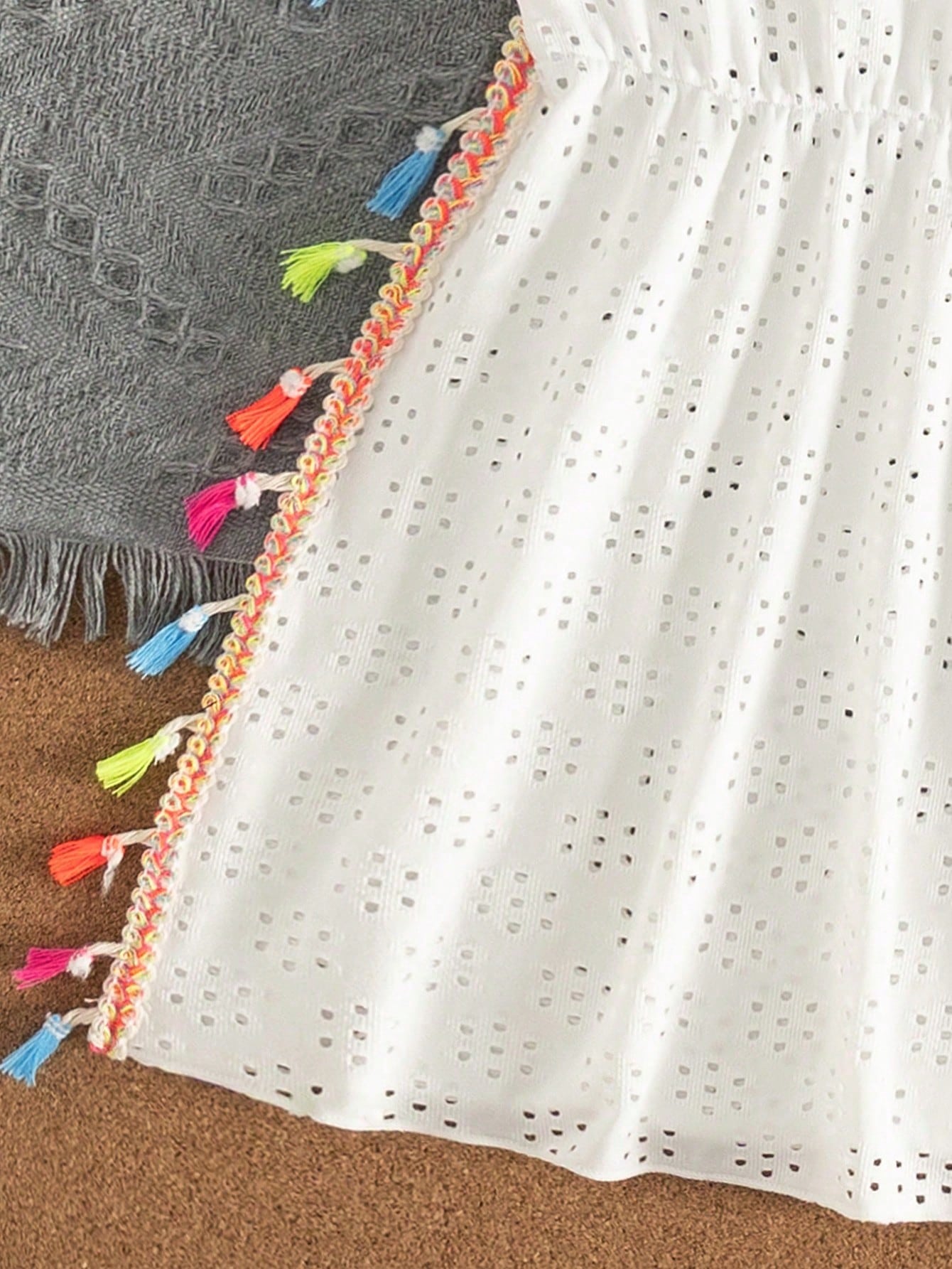 Tween girl white swimsuit cover up with colorful tassel fringe, hollow crochet mesh, round neck, short sleeves, and semi-sheer beach dress style.