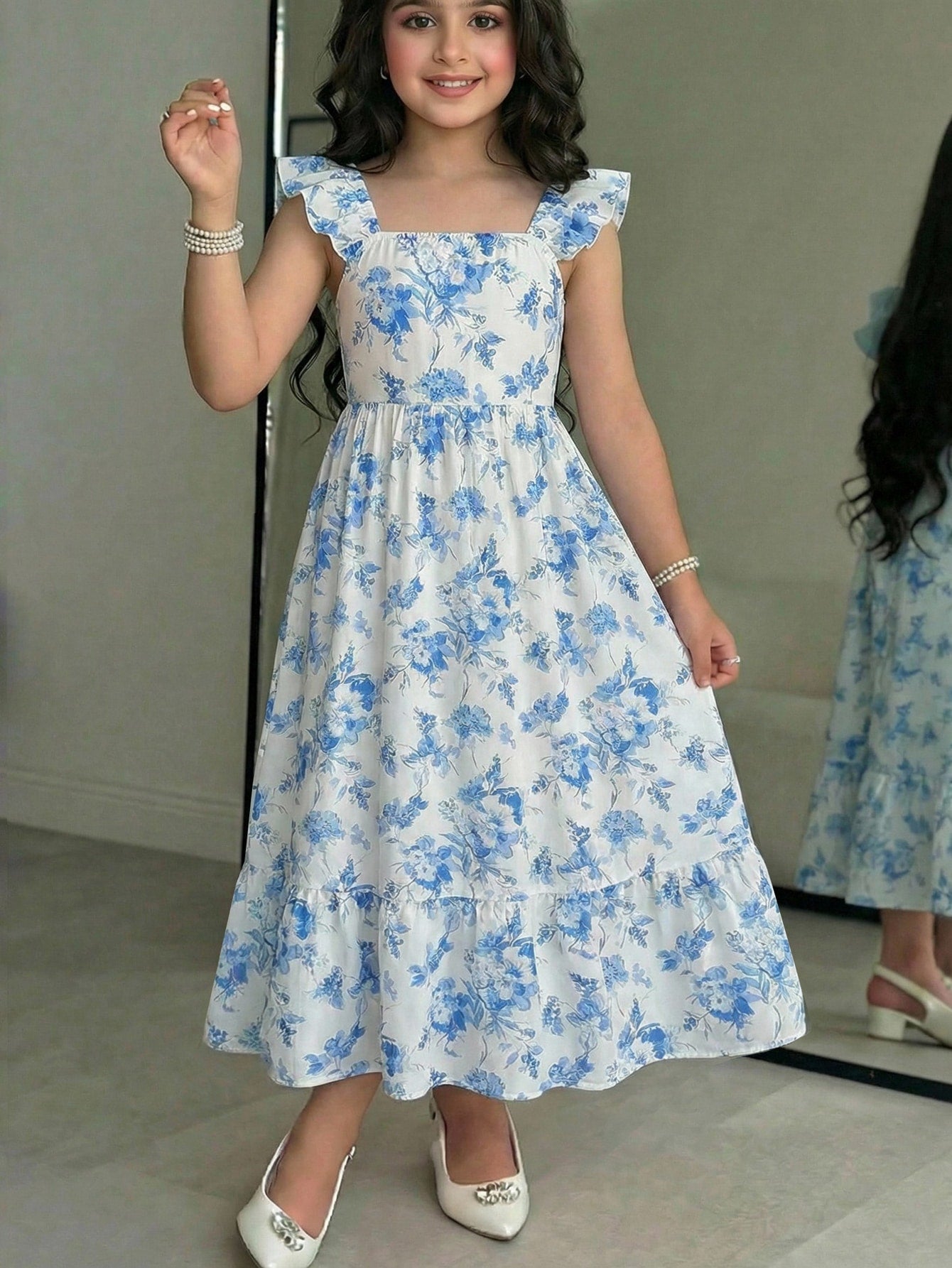 Tween girl multicolor floral vacation dress with square neck, ruffle details, shirred bodice, sleeveless A-line shape, high waist, and flounce hem.