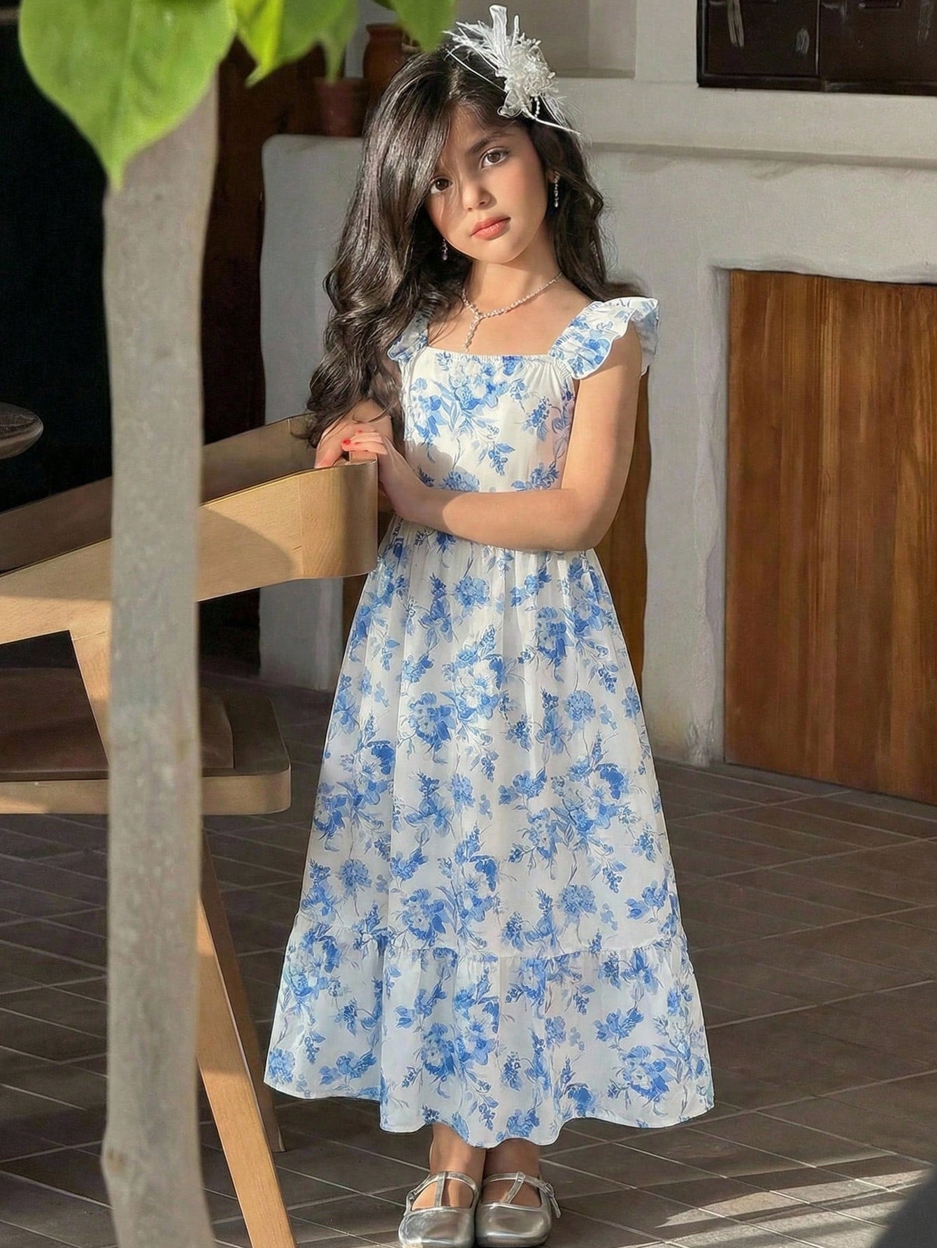 Tween girl multicolor floral vacation dress with square neck, ruffle details, shirred bodice, sleeveless A-line shape, high waist, and flounce hem.