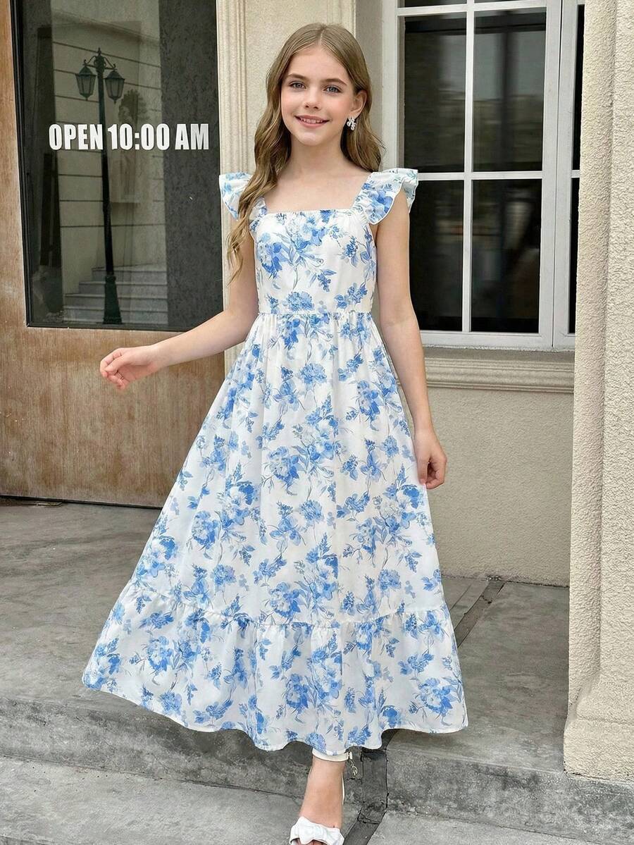 Blue floral print long vacation dress for tween girls featuring an A-line high waist silhouette with ruffle details and spaghetti straps.