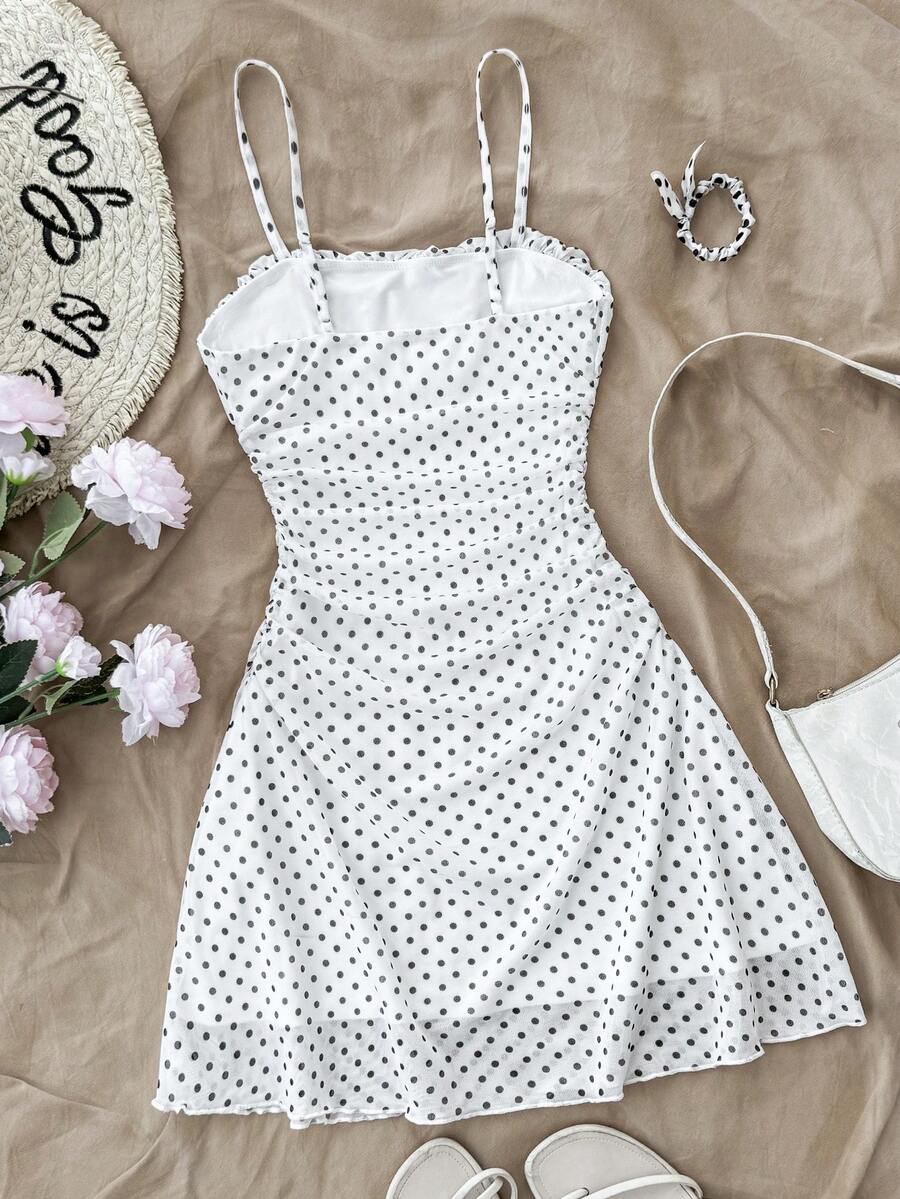 Tween girl yellow mini sundress with large pink floral hibiscus print, spaghetti straps, high waist, flared hem, and sleeveless cami style for summer beach wear