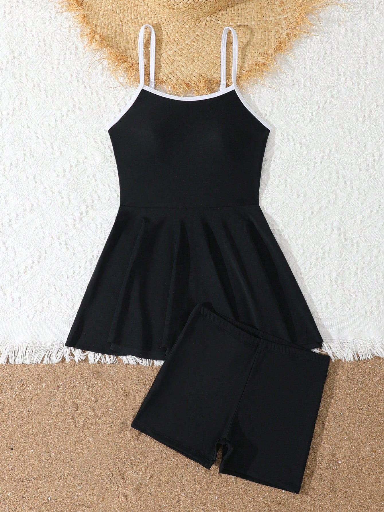 Tween girls black two-piece tankini swimwear set featuring a spaghetti strap sleeveless top with cutout detail and contrast piping, paired with short swim shorts.