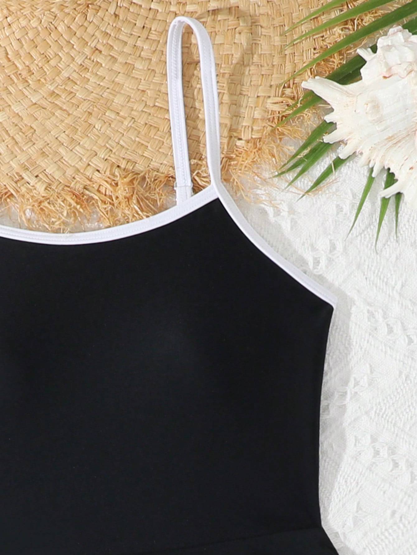 Tween girls black two-piece tankini swimwear set featuring a spaghetti strap sleeveless top with cutout detail and contrast piping, paired with short swim shorts.