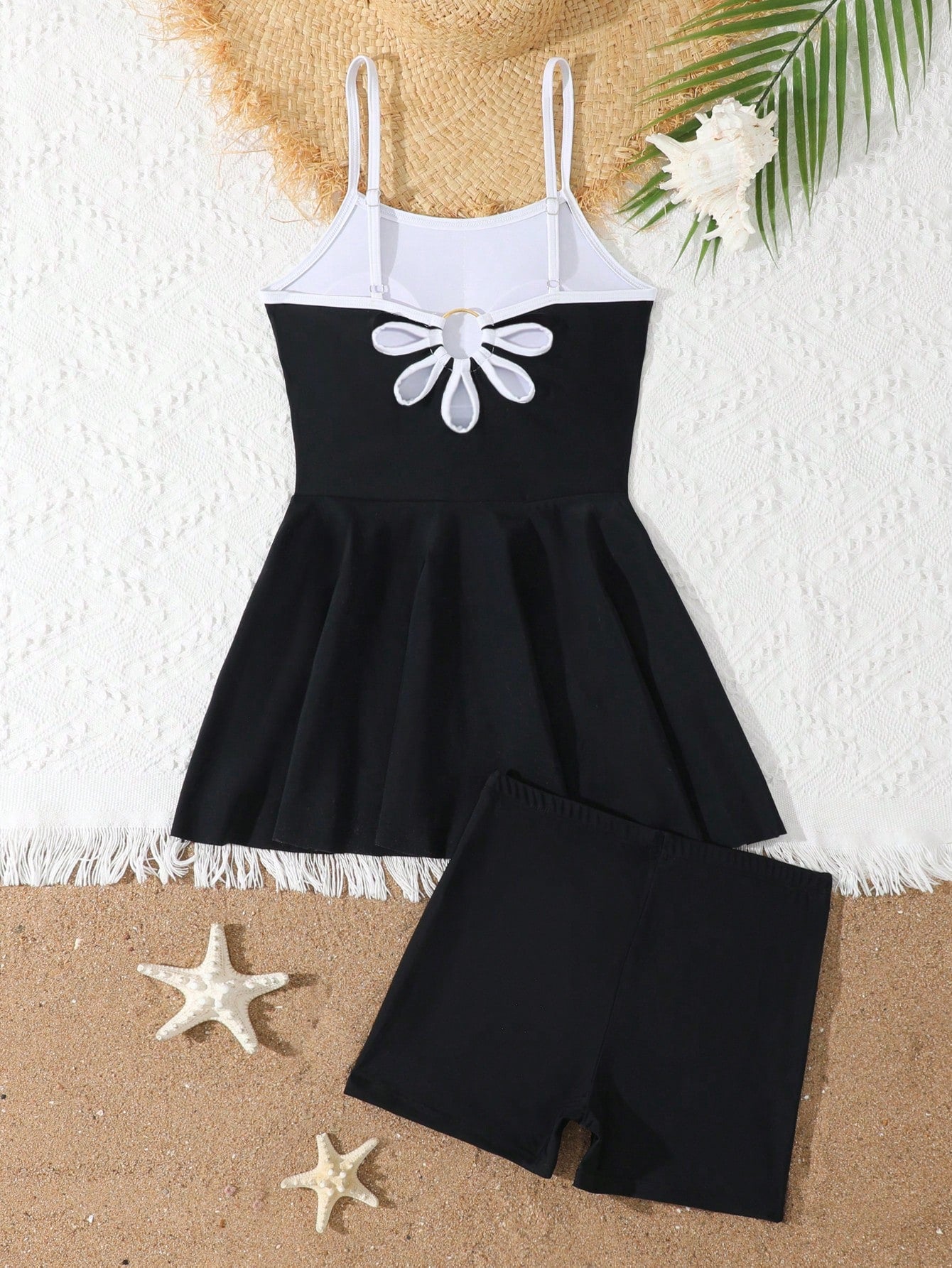 Tween girls black two-piece tankini swimwear set featuring a spaghetti strap sleeveless top with cutout detail and contrast piping, paired with short swim shorts.