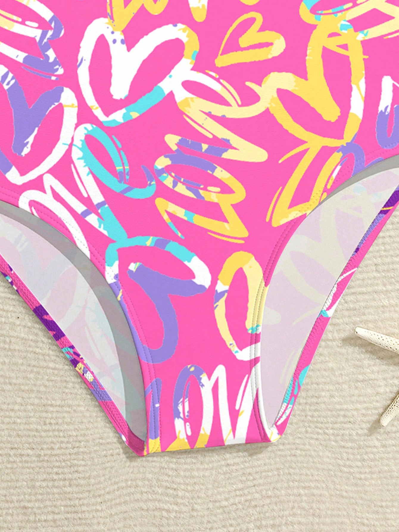 Baby pink girls one piece swimsuit with all over print, scoop neck, cut out detail, fitted shape, and lined body for tween beach and pool wear