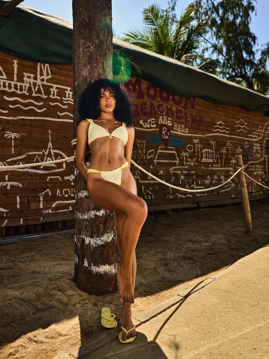 Women's 2-piece triangle cup bikini set in solid color featuring woven pearl shell decoration, halter neckline, and high-waist side-tie ruched bottoms.