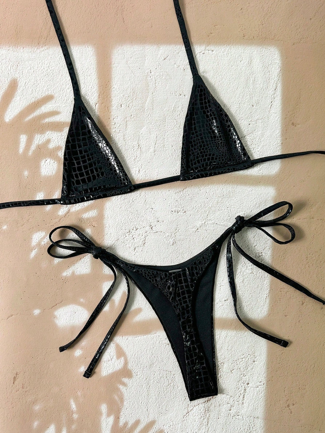 Black 2-piece snakeskin textured halter bikini set for women featuring high waist tie side bottoms and triangle cups.