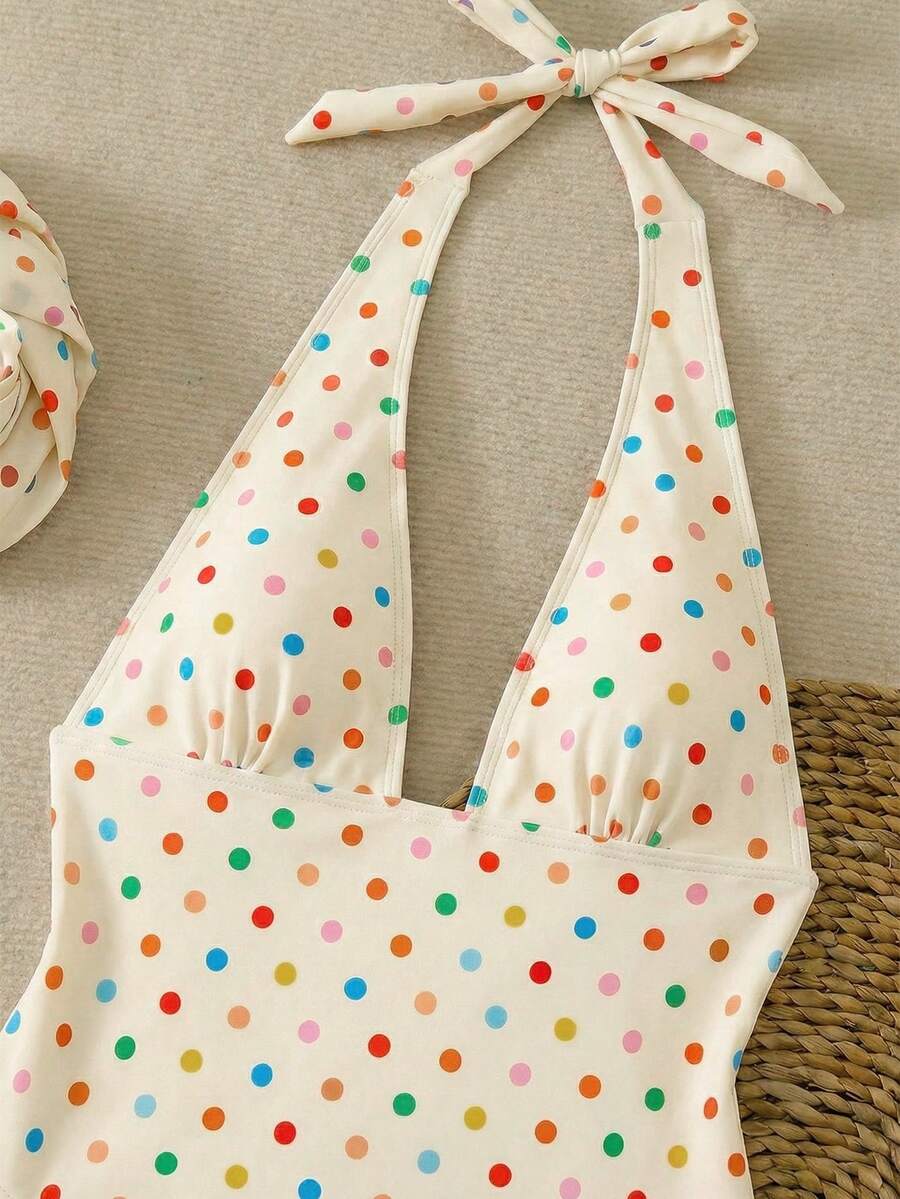 Women's apricot polka dot two-piece swimsuit featuring an asymmetrical halter backless top with knot tie detail and high-waisted bottoms.