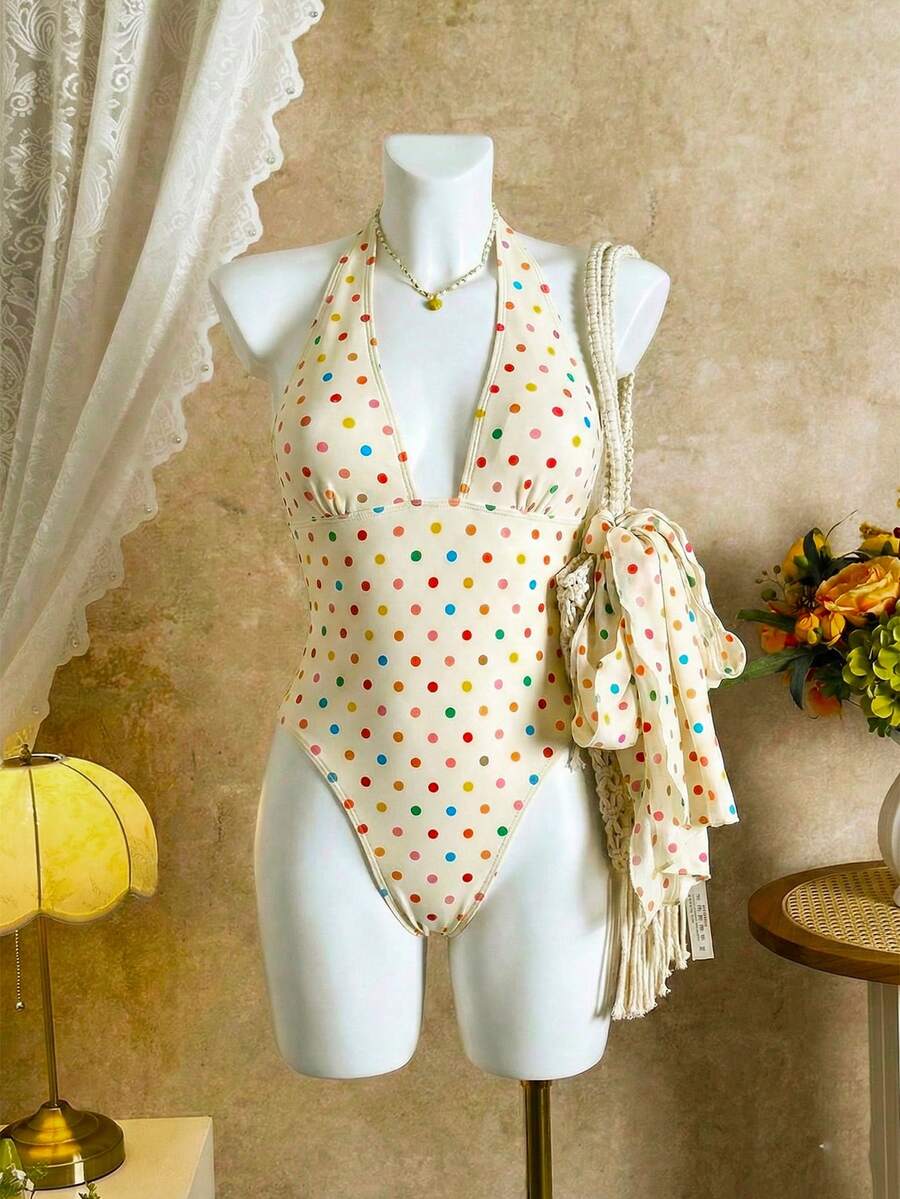 Women's apricot polka dot two-piece swimsuit featuring an asymmetrical halter backless top with knot tie detail and high-waisted bottoms.