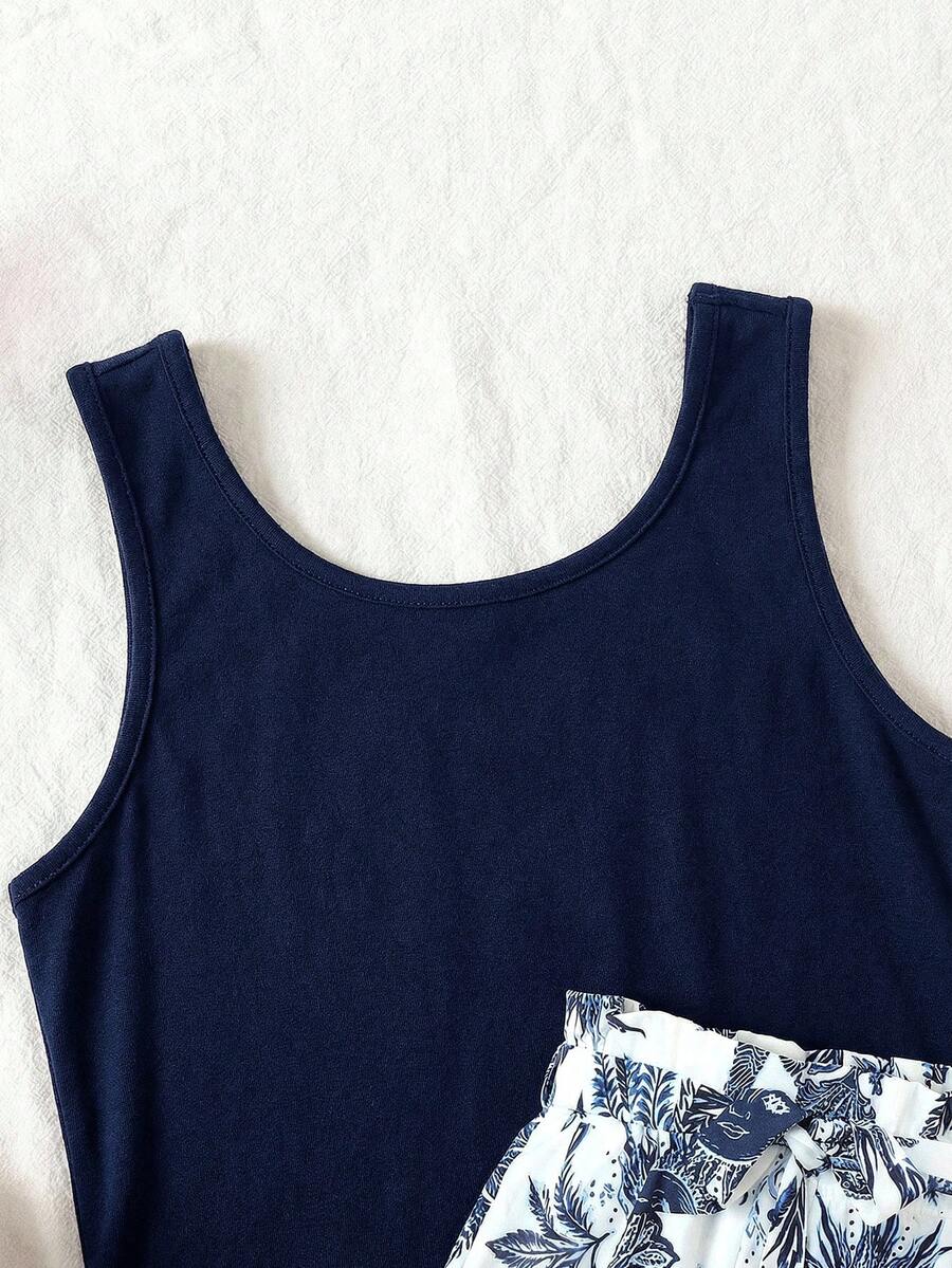 Tween girl wearing a casual 2-piece set featuring a black rib-knit scoop neck tank top and leopard print paperbag waist shorts with a matching belt.