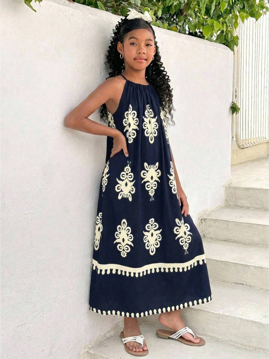 Tween girls green floral print cami dress with halter neckline, sleeveless cut, zipper detail, flared hem, and long vacation style silhouette.