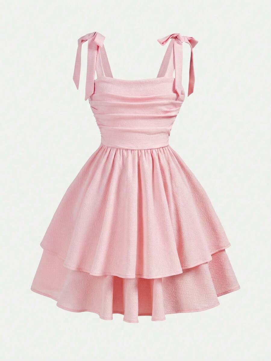 Tween girl wearing a pink tiered off-the-shoulder midi dress with shirred high waist and layered hem