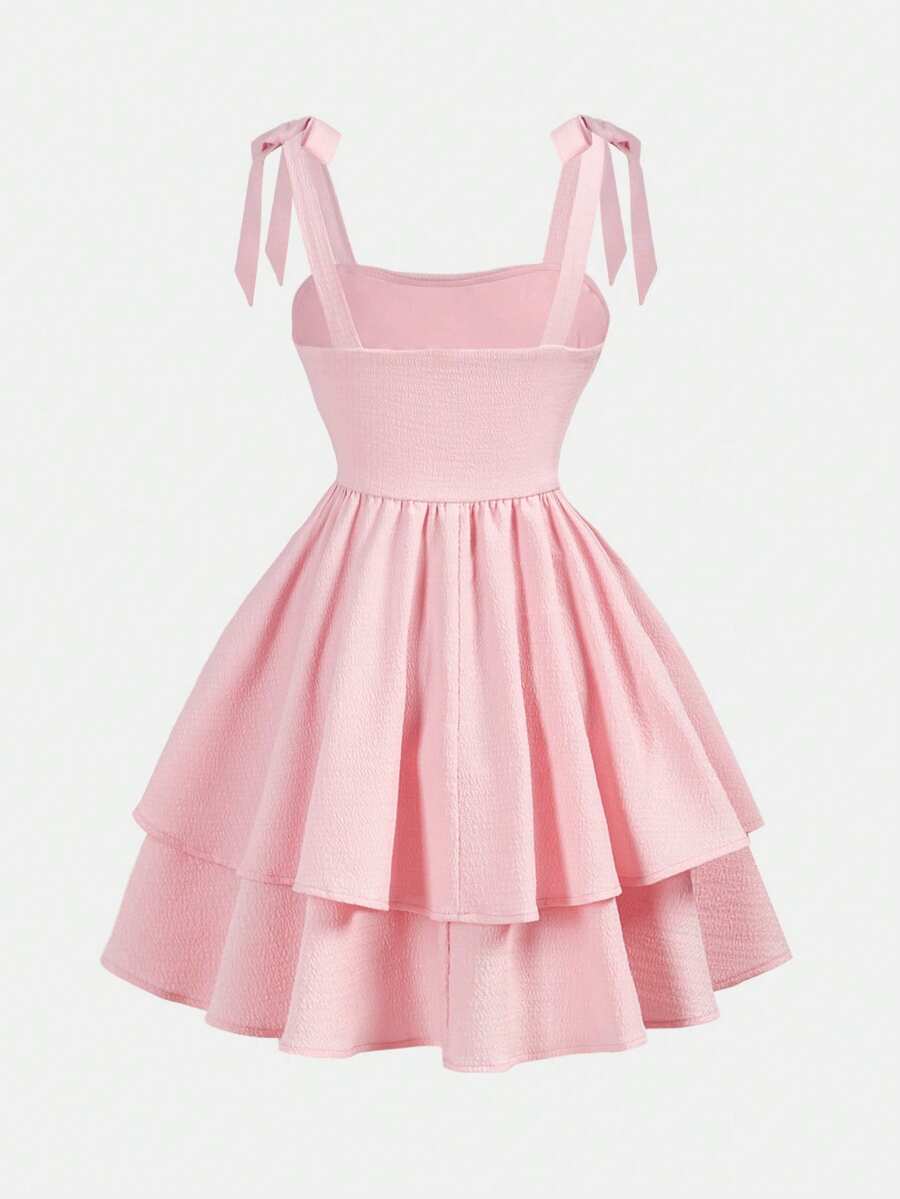 Tween girl wearing a pink tiered off-the-shoulder midi dress with shirred high waist and layered hem