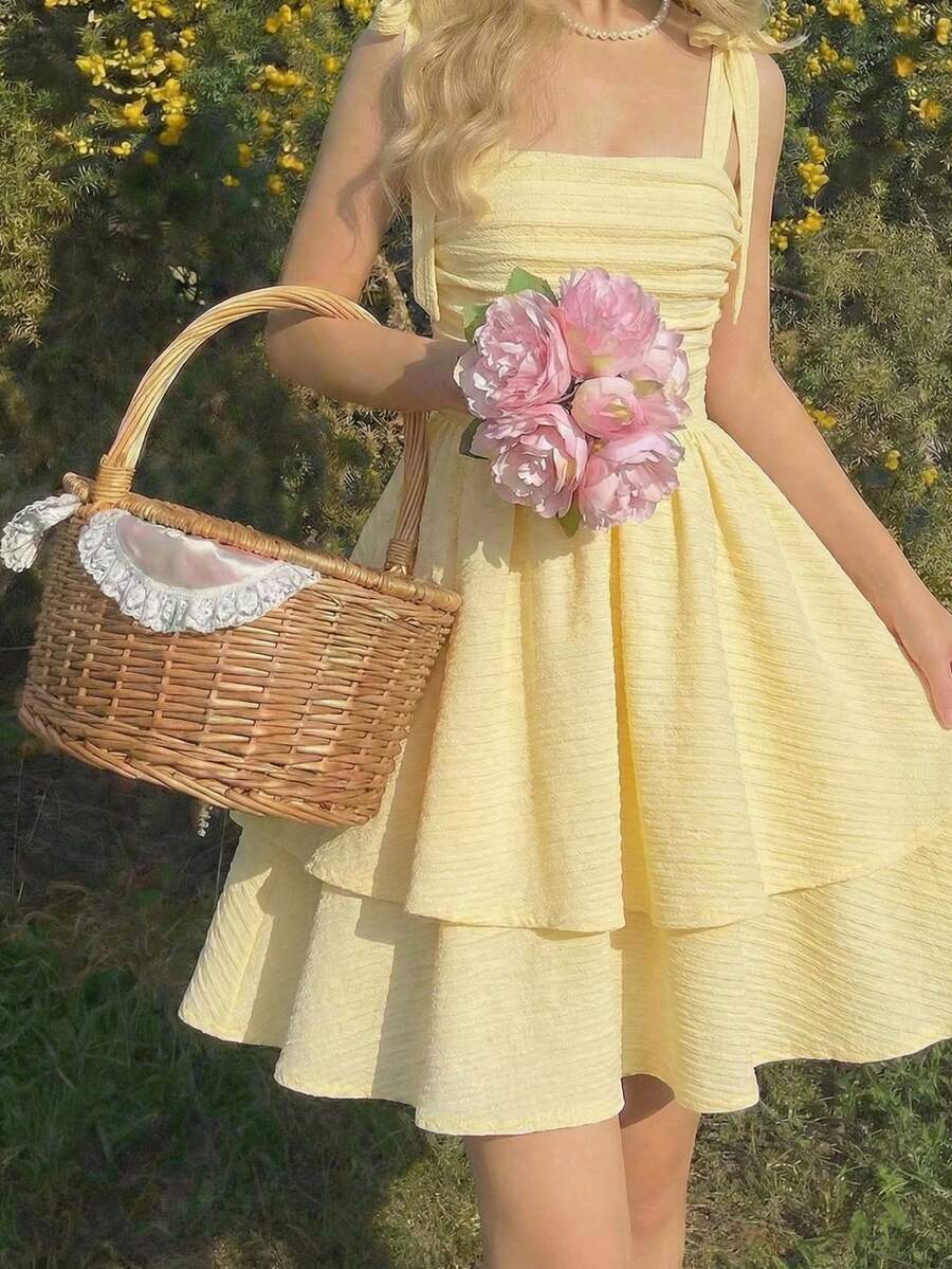 Tween girl wearing a pink tiered off-the-shoulder midi dress with shirred high waist and layered hem