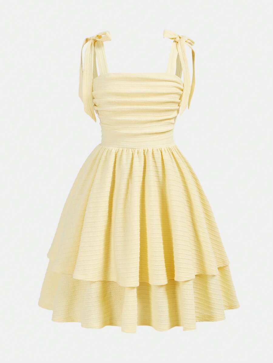 Tween girl wearing a pink tiered off-the-shoulder midi dress with shirred high waist and layered hem