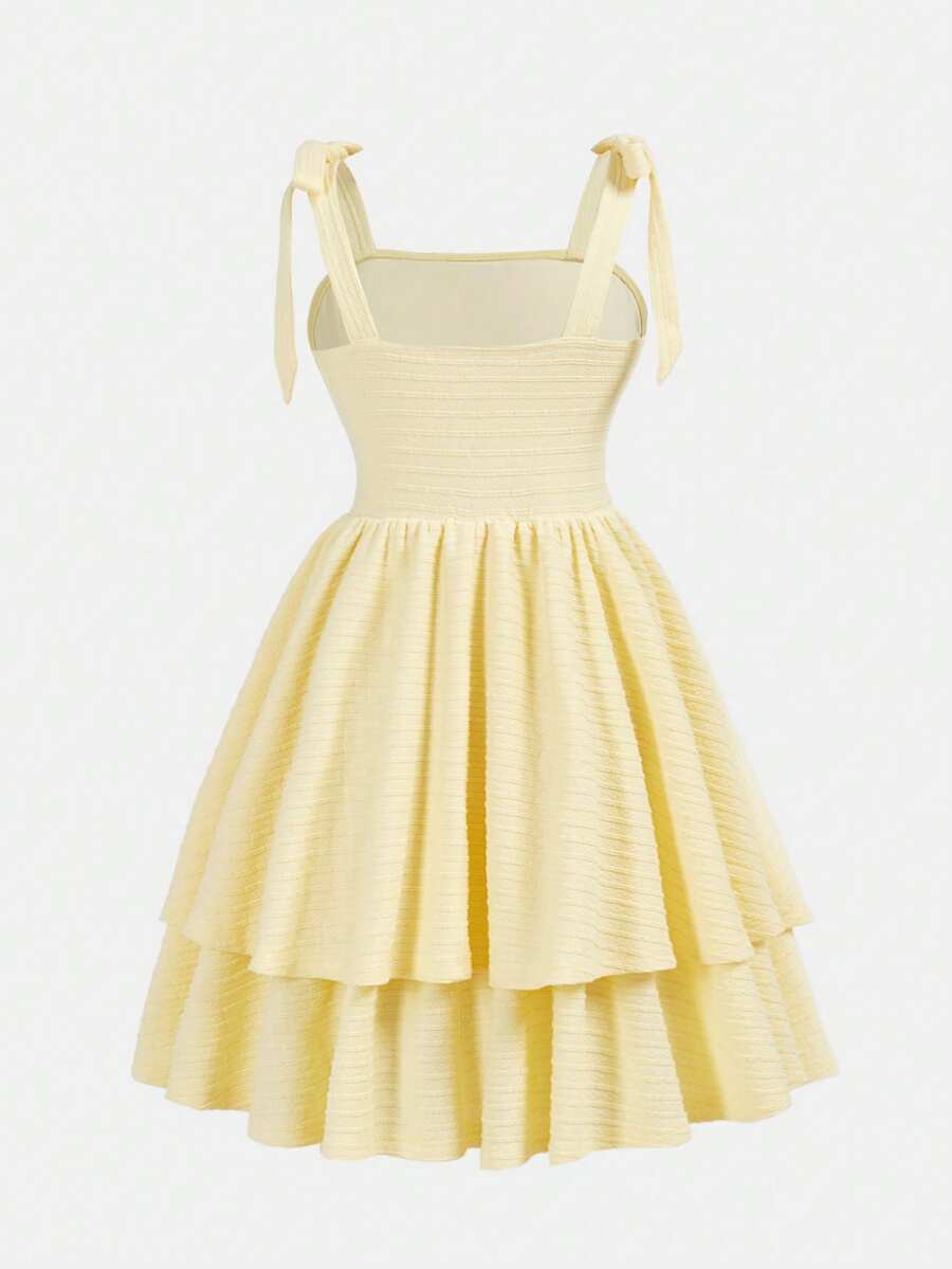 Tween girl wearing a pink tiered off-the-shoulder midi dress with shirred high waist and layered hem
