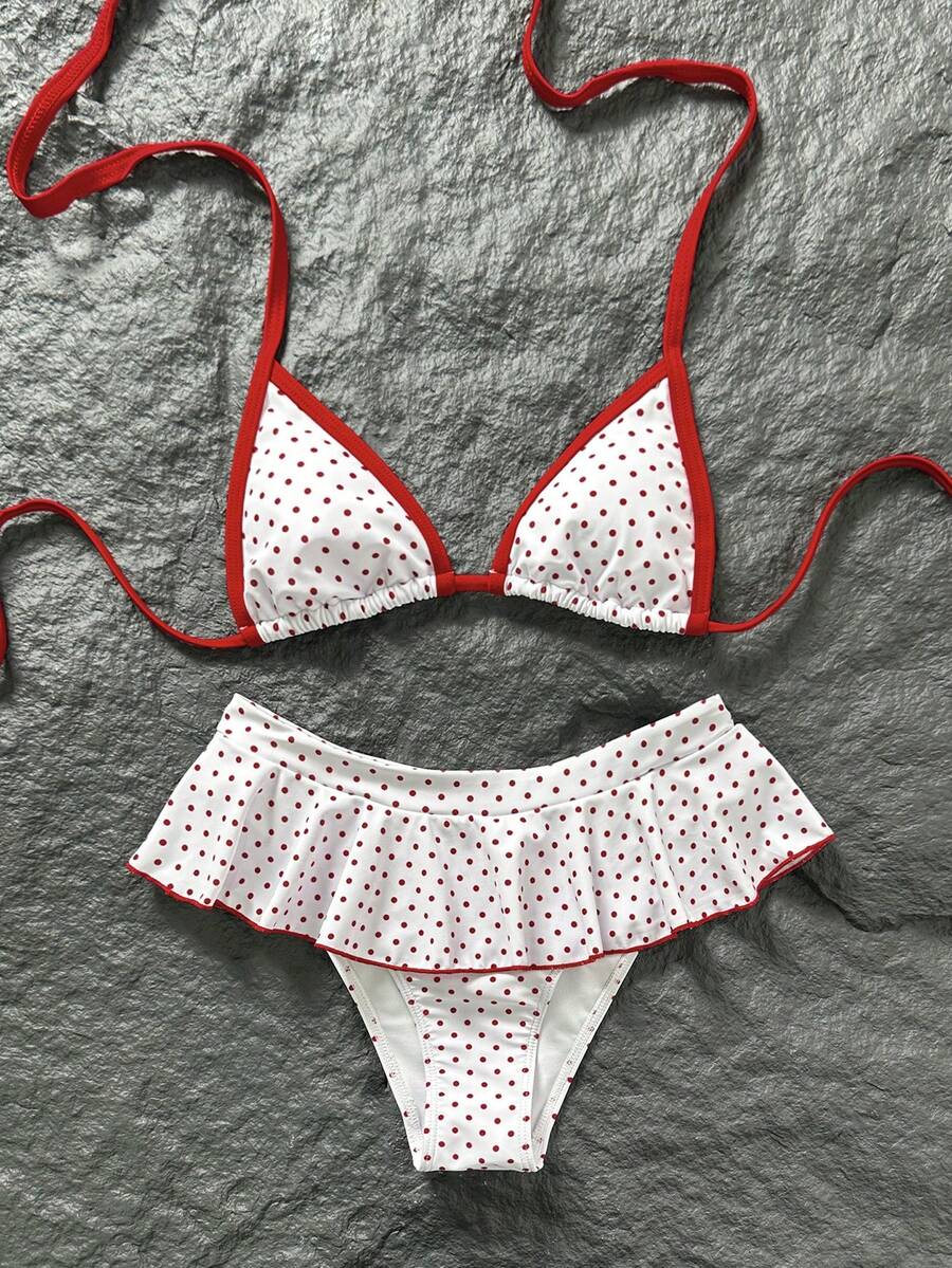 Women's 70s retro black and white polka dot bikini set featuring a halter triangle top and ultra low waist bottoms.