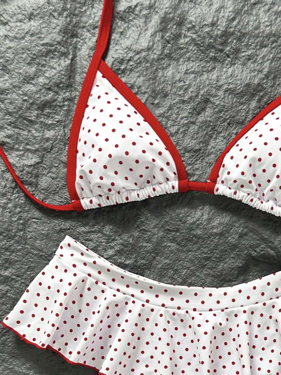 Women's 70s retro black and white polka dot bikini set featuring a halter triangle top and ultra low waist bottoms.