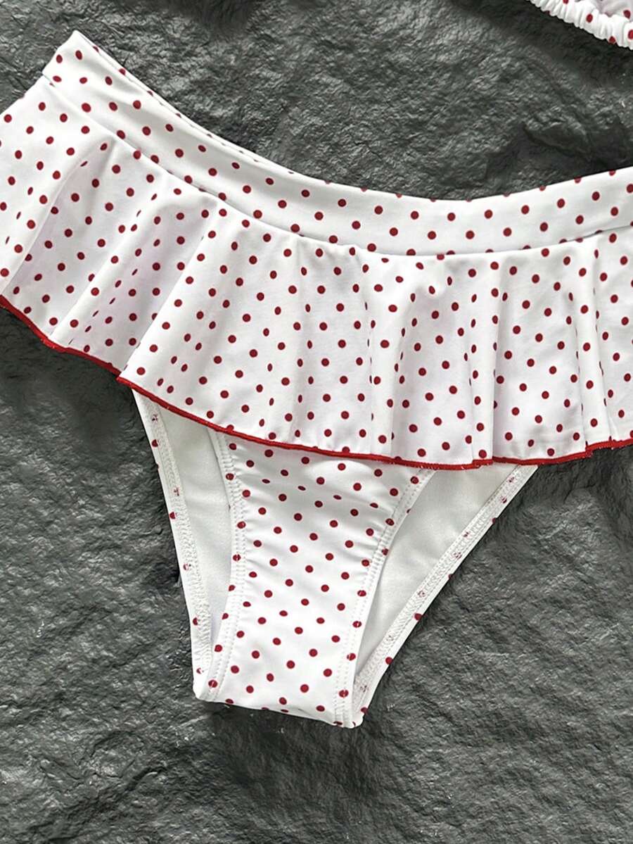 Women's 70s retro black and white polka dot bikini set featuring a halter triangle top and ultra low waist bottoms.