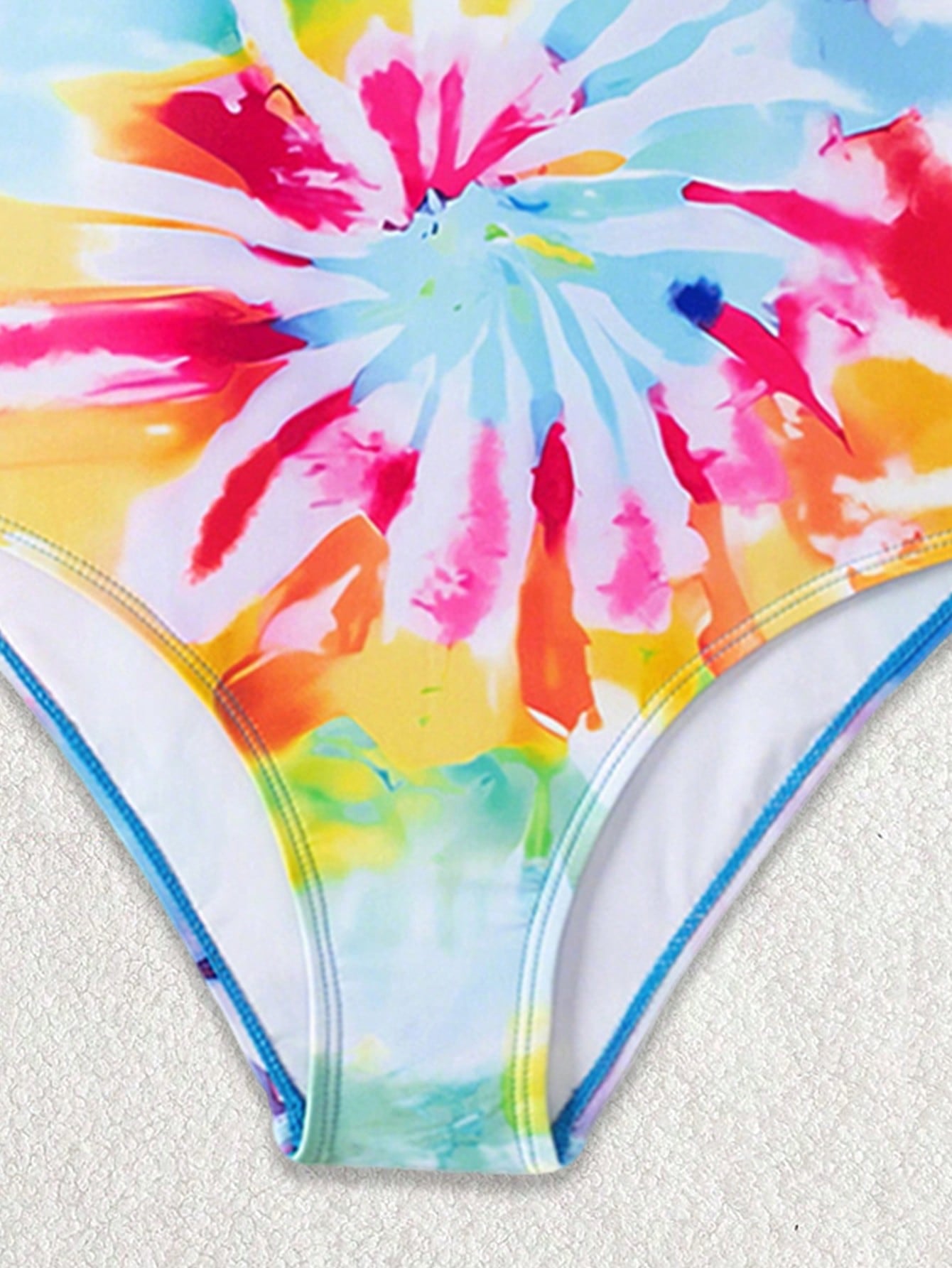 Multicolor plant print one-piece swimsuit for tween girls with spaghetti neckline, adjustable straps, fitted shape, and lined body for summer swimming and vacation.