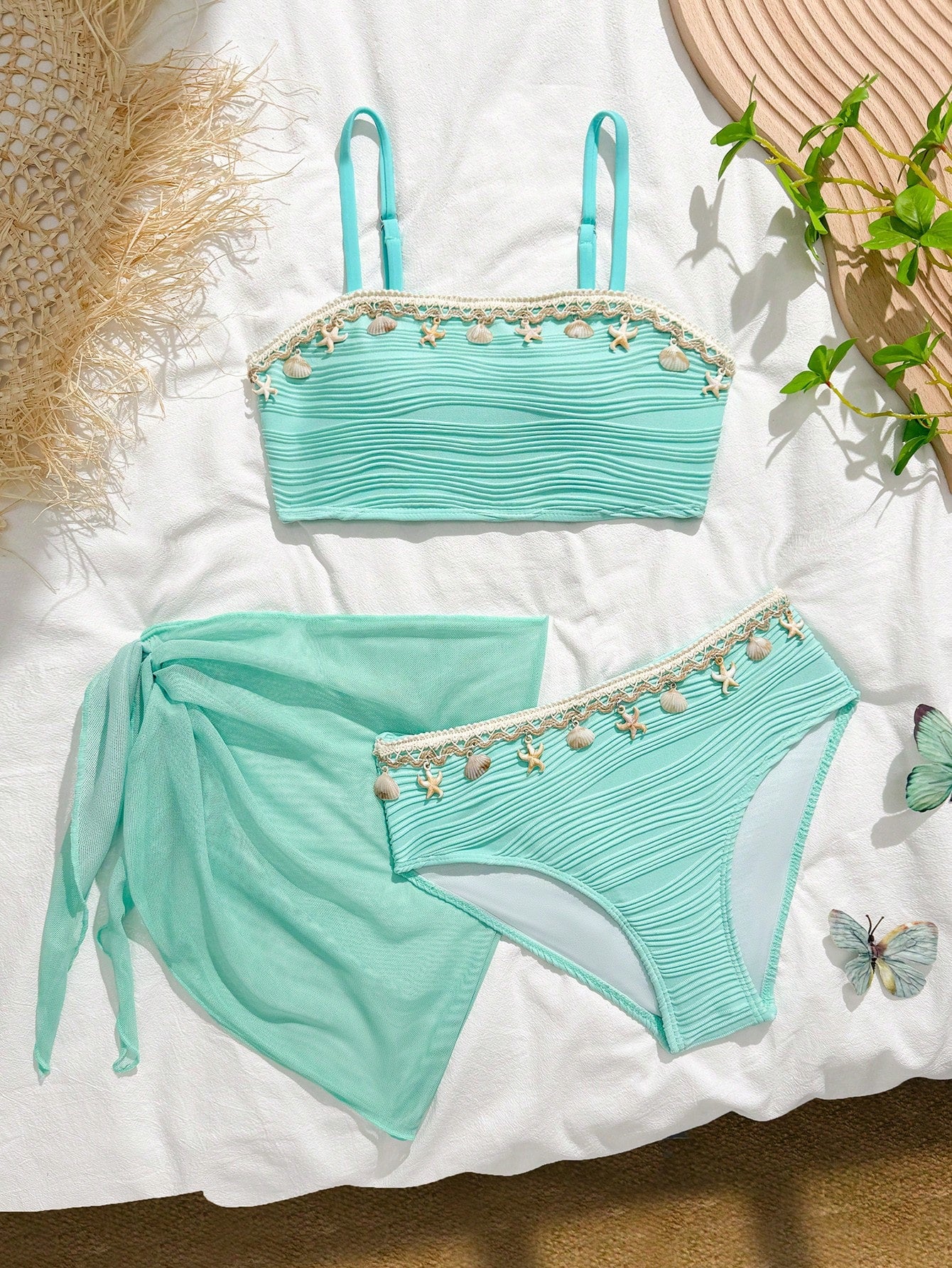 Tween girls bikini set with shell and starfish woven band details, spaghetti strap sleeveless top, and mid-waist skirt-style bottom in blue.