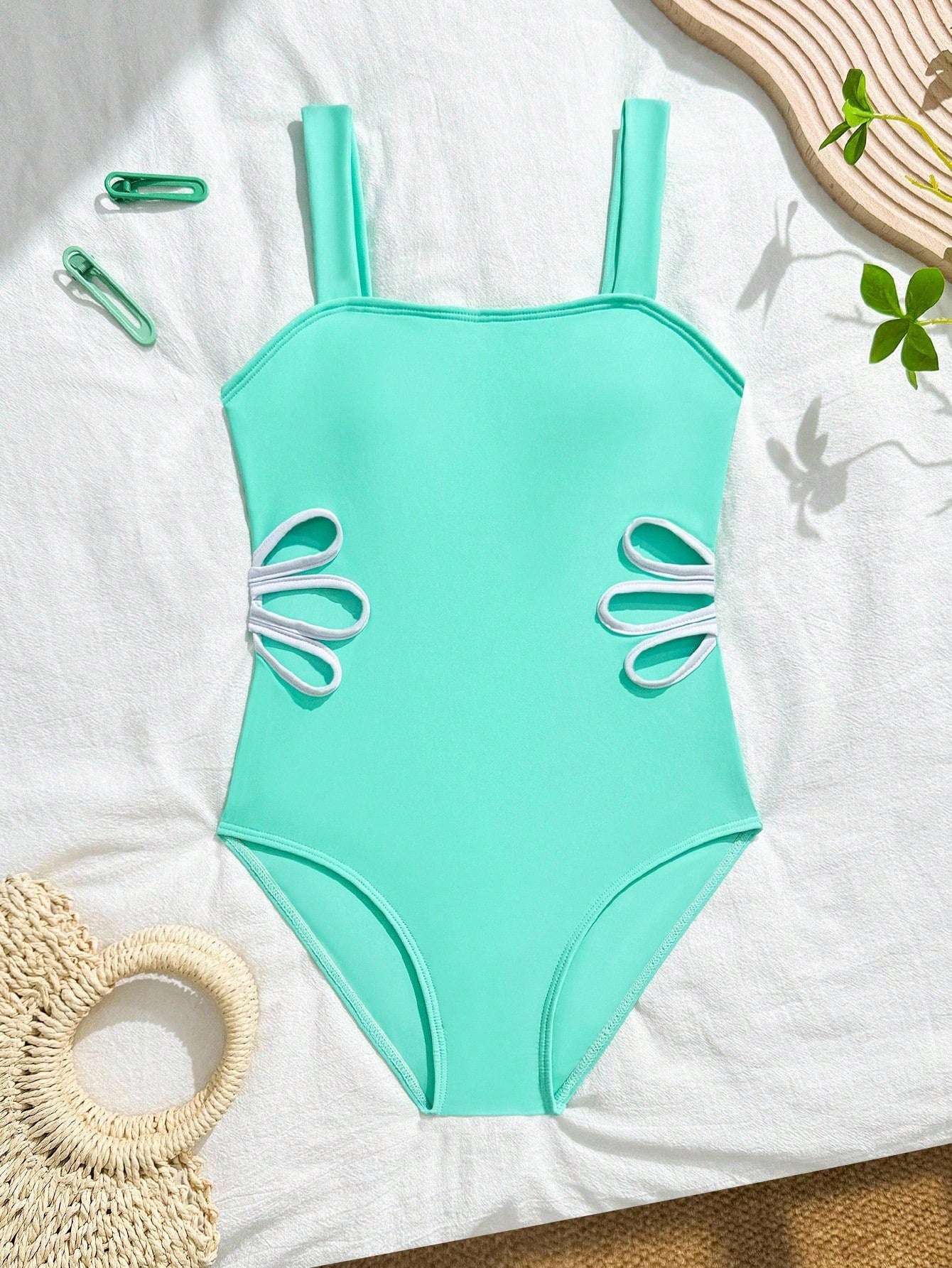 Tween girls one-piece swimsuit with a floral plant print, spaghetti straps, and a mid-waist fit in black.