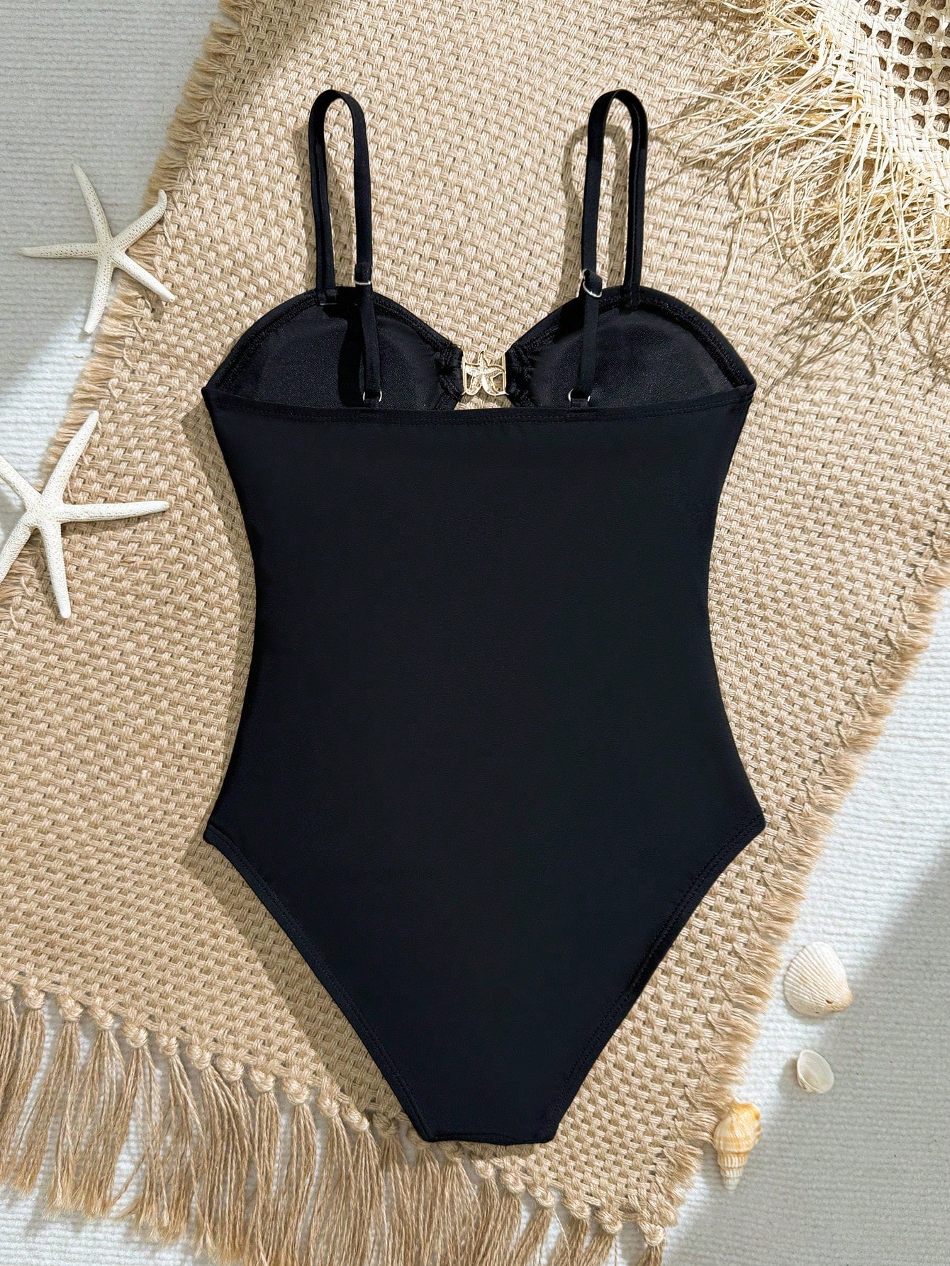 Black one-piece swimsuit for tween girls with cut out detail, spaghetti straps, high waist bottom, wireless bra, and fitted vacation swimwear style.