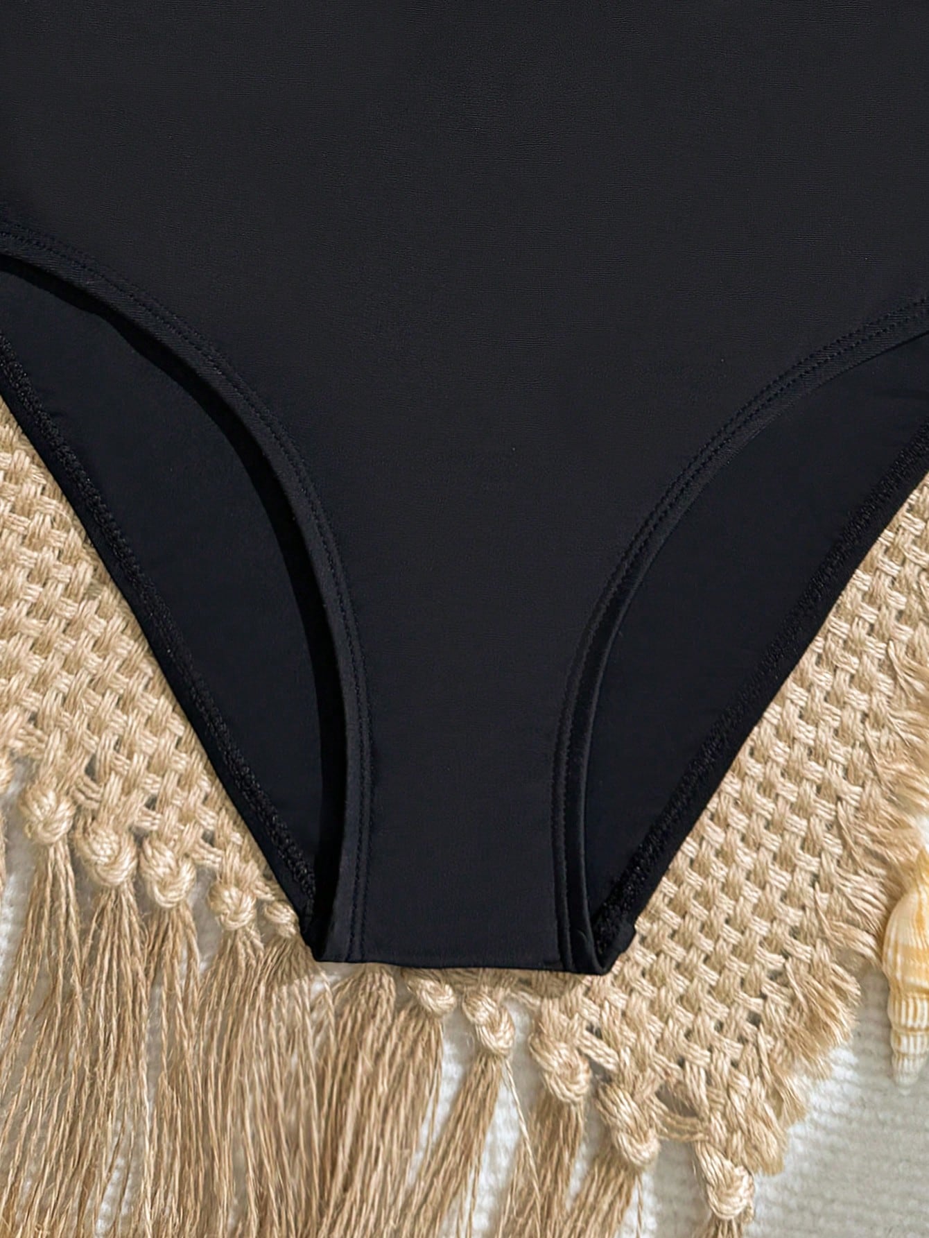 Black one-piece swimsuit for tween girls with cut out detail, spaghetti straps, high waist bottom, wireless bra, and fitted vacation swimwear style.