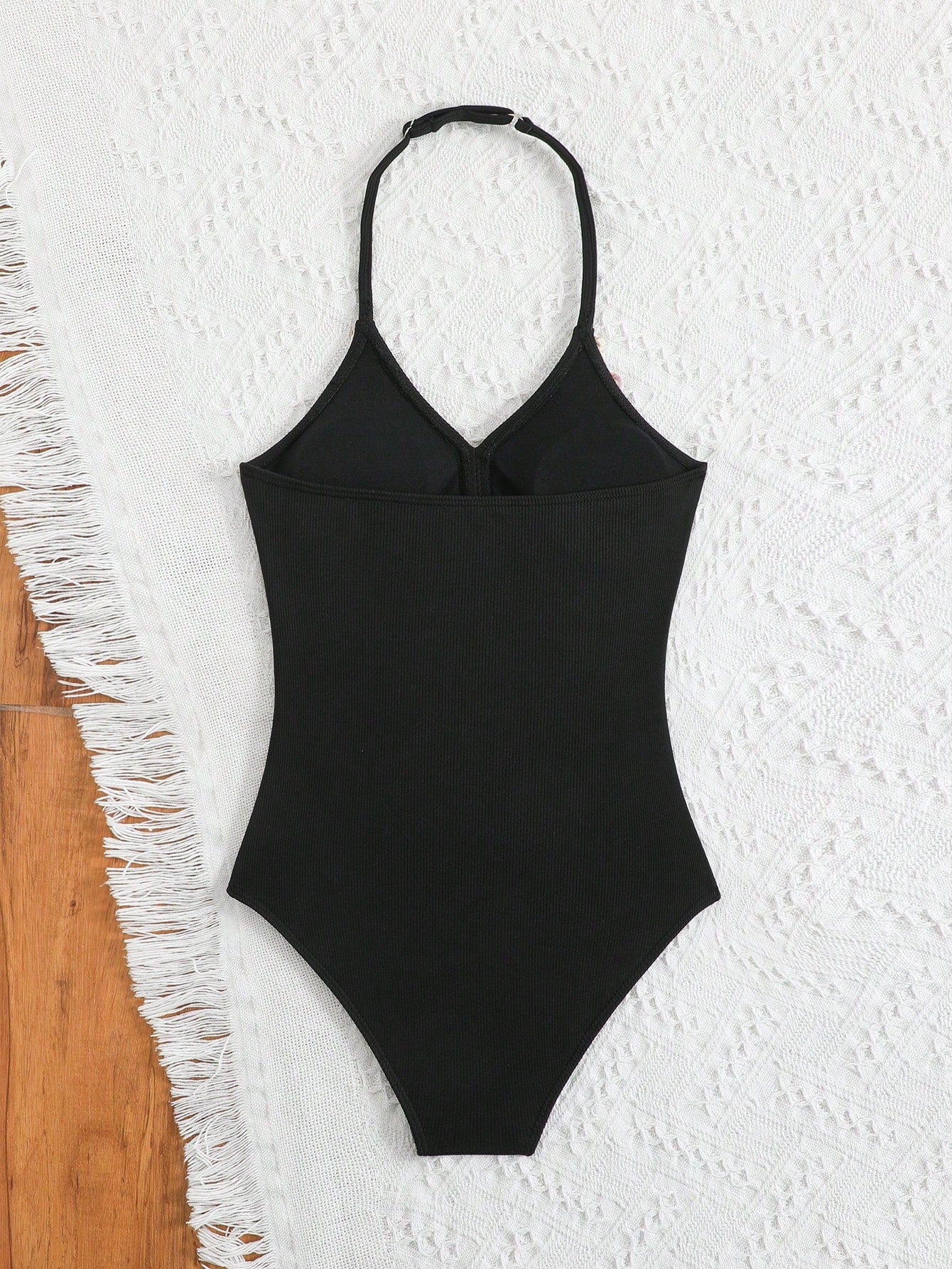 Black tween girls one-piece swimsuit with halter neckline, shell embroidery detail, ribbed texture, and mid-waist bottom for beach, swimming, and vacation wear.