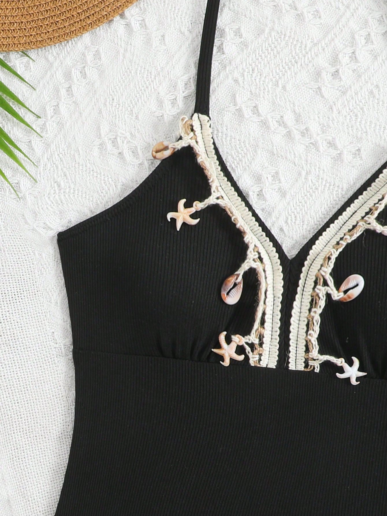 Black tween girls one-piece swimsuit with halter neckline, shell embroidery detail, ribbed texture, and mid-waist bottom for beach, swimming, and vacation wear.