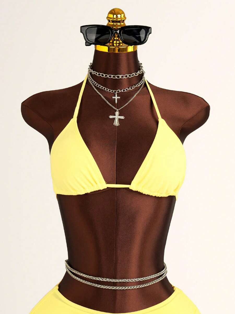 Women's black 3-piece bikini set featuring a halter triangle top with removable padding, high-waisted bottoms, and a knee-length mesh skirt with tie details.