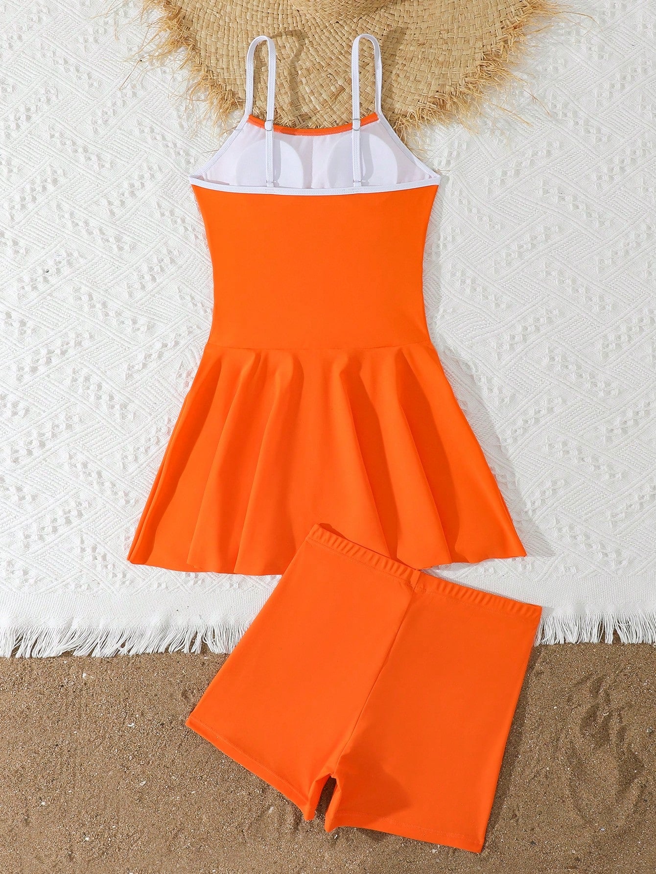 Tween girls black two-piece tankini swimwear set featuring a spaghetti strap sleeveless top with cutout detail and contrast piping, paired with short swim shorts.