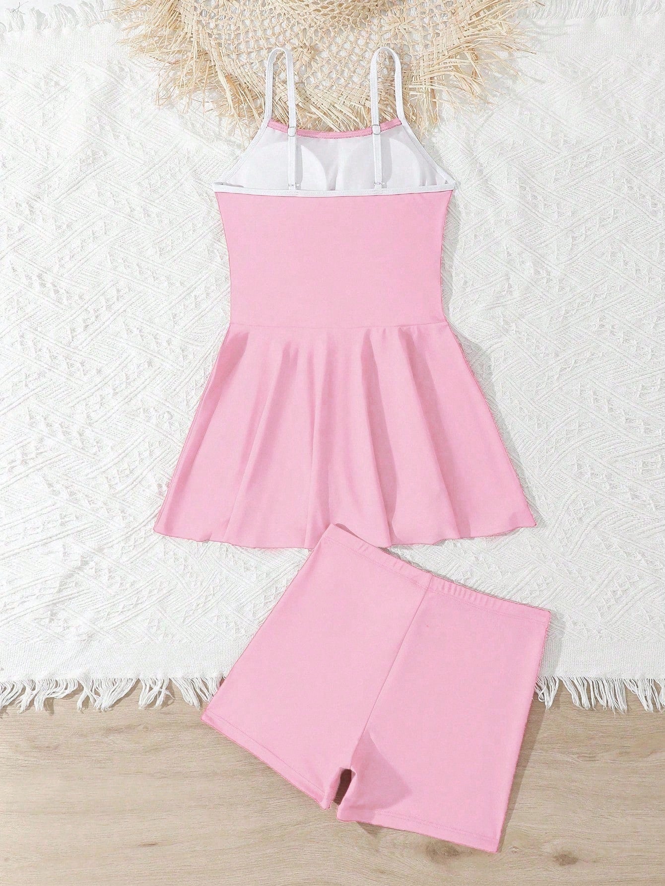 Tween girls black two-piece tankini swimwear set featuring a spaghetti strap sleeveless top with cutout detail and contrast piping, paired with short swim shorts.