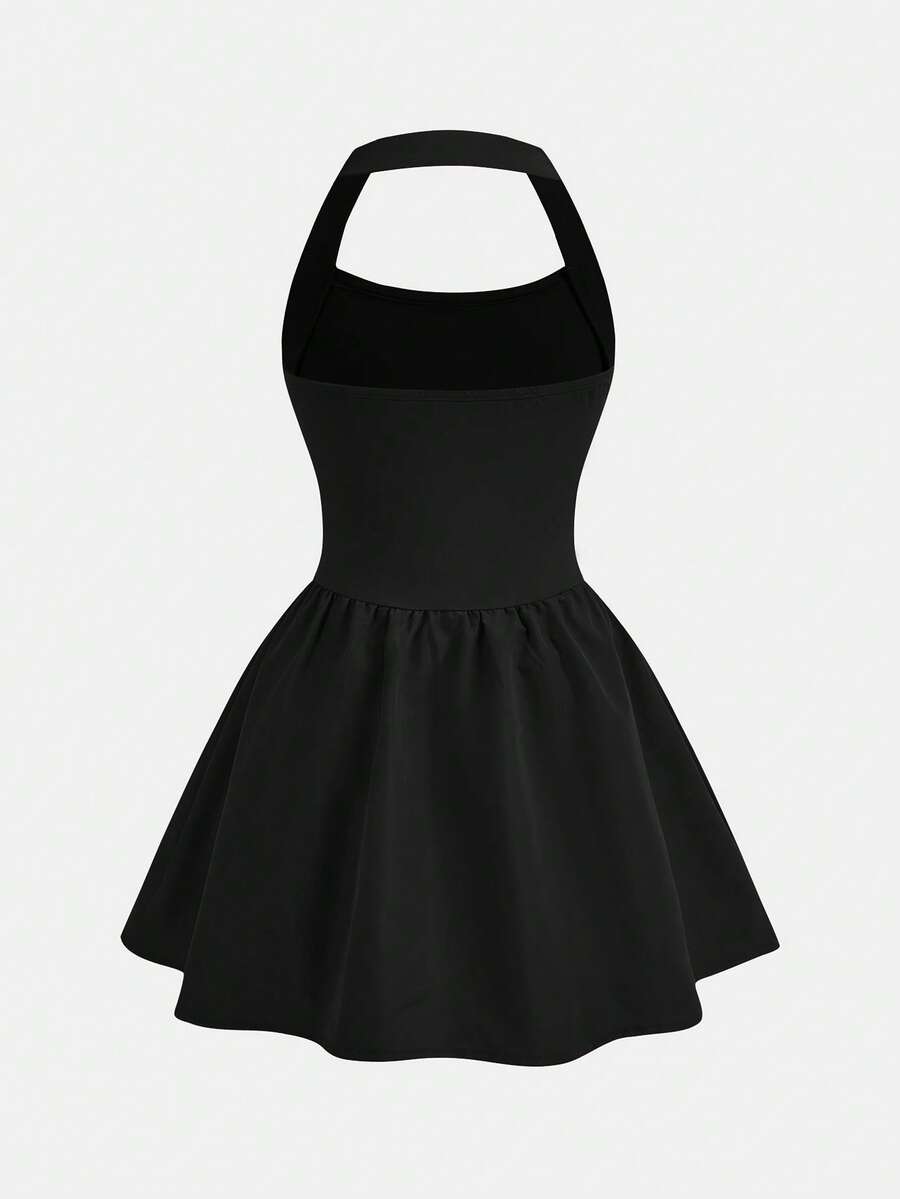 Black sleeveless halter polka dot mini dress for tween girls featuring a high waist and flared hem