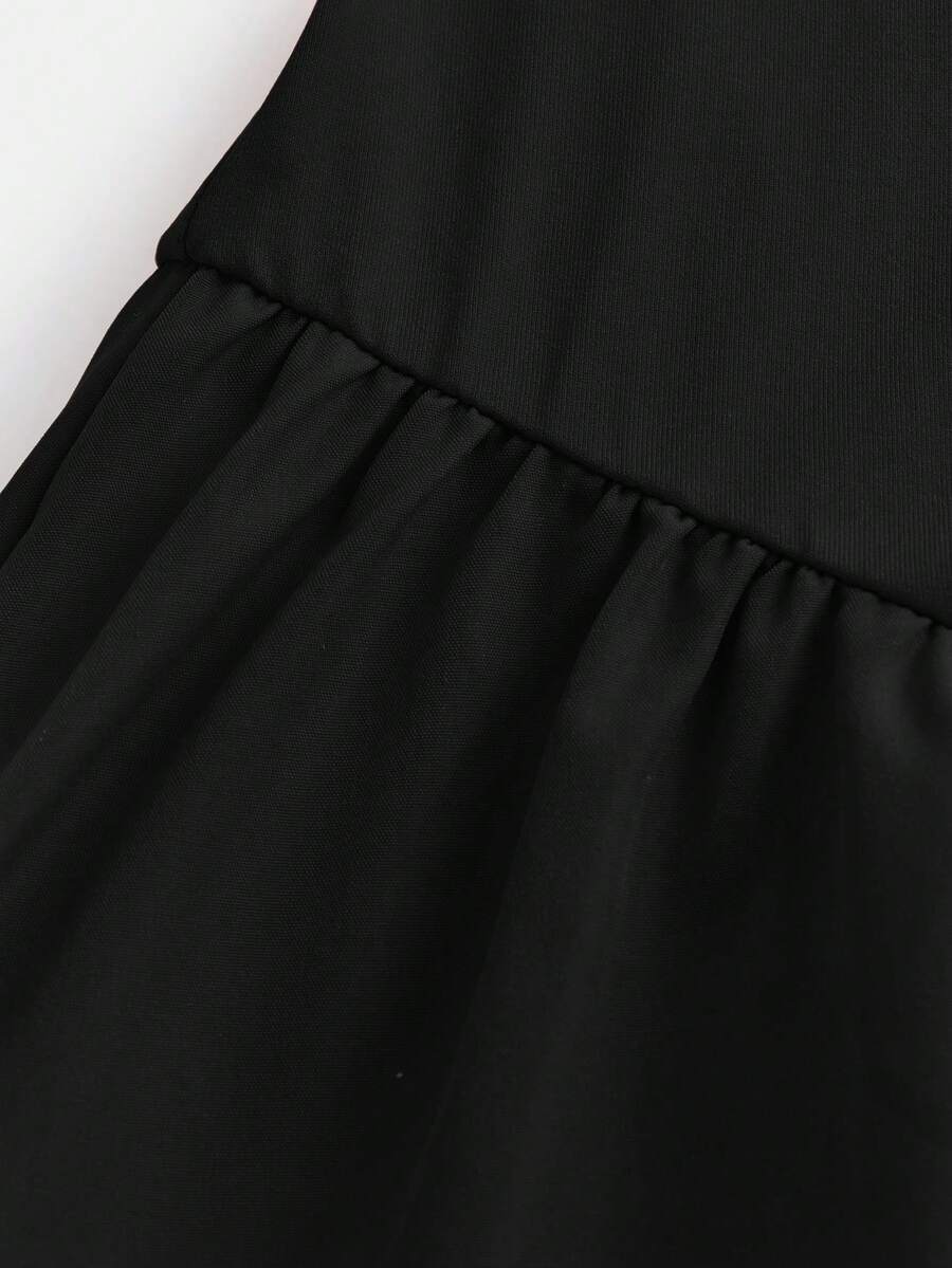 Black sleeveless halter polka dot mini dress for tween girls featuring a high waist and flared hem