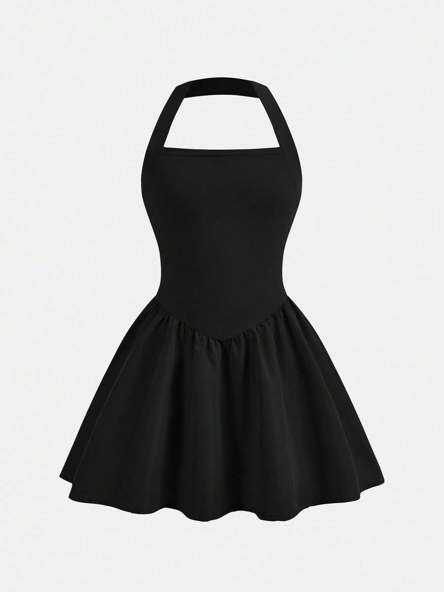 Black sleeveless halter polka dot mini dress for tween girls featuring a high waist and flared hem