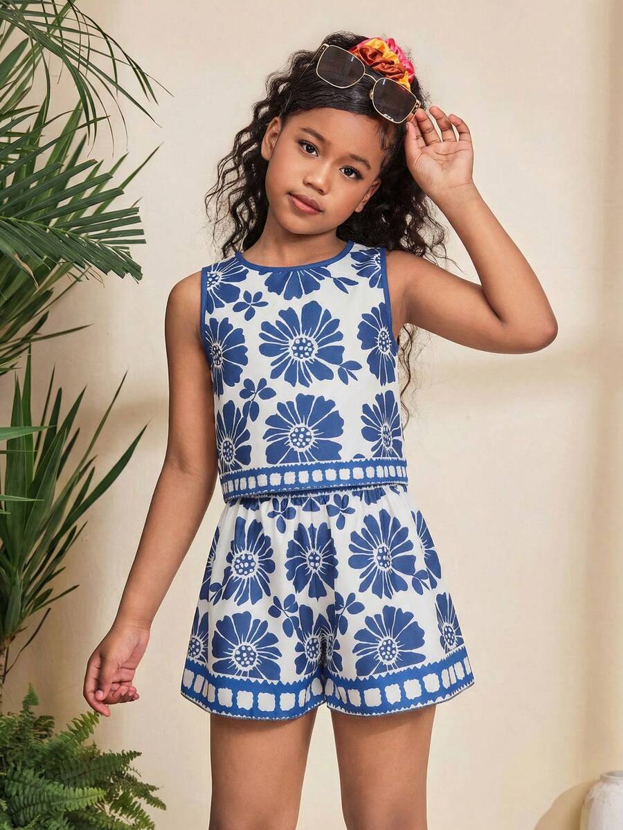 Tween girl wearing a tropical floral print two-piece vacation set featuring a sleeveless round neck tank top with button details and matching shorts.