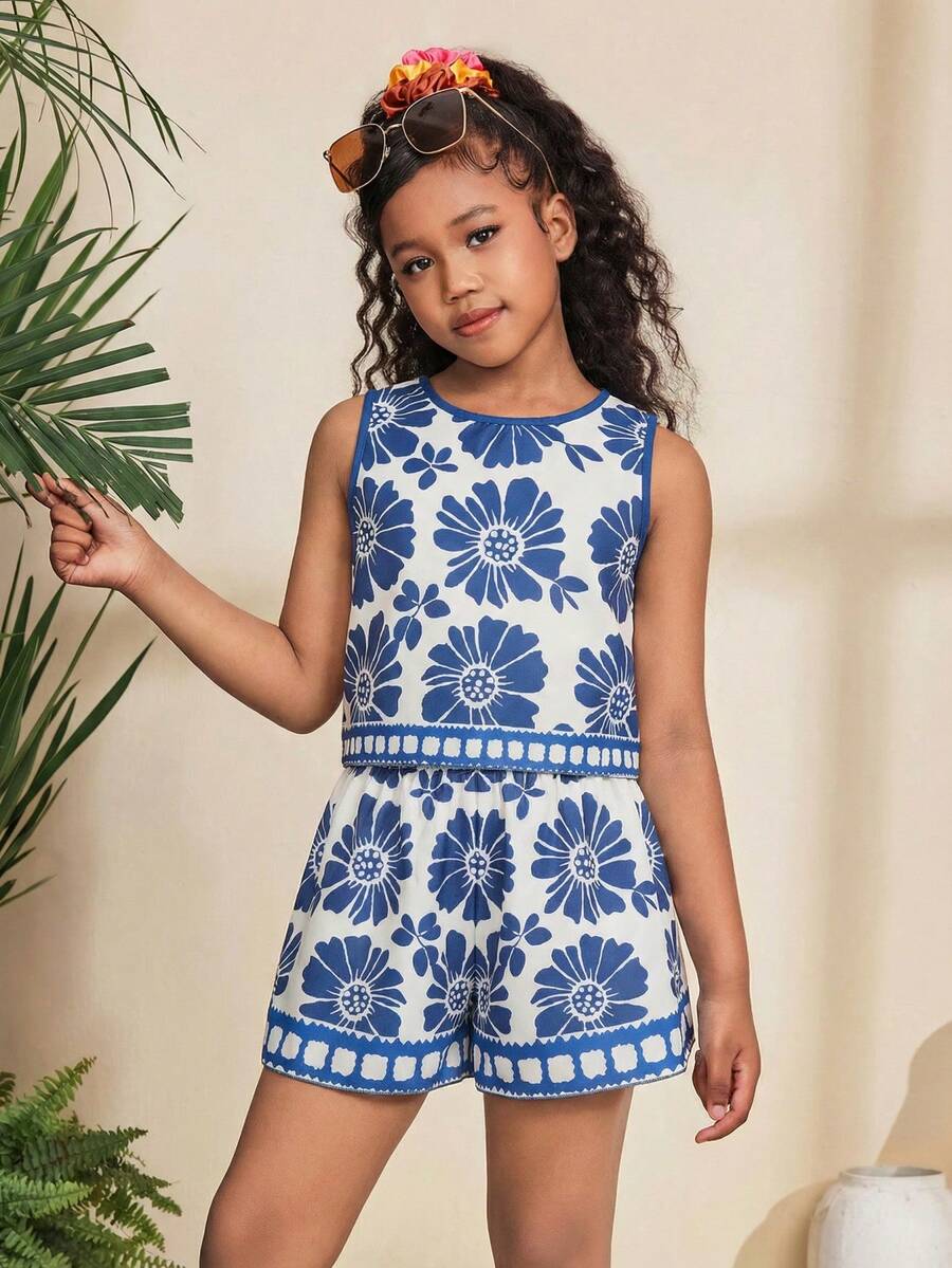 Tween girl wearing a tropical floral print two-piece vacation set featuring a sleeveless round neck tank top with button details and matching shorts.