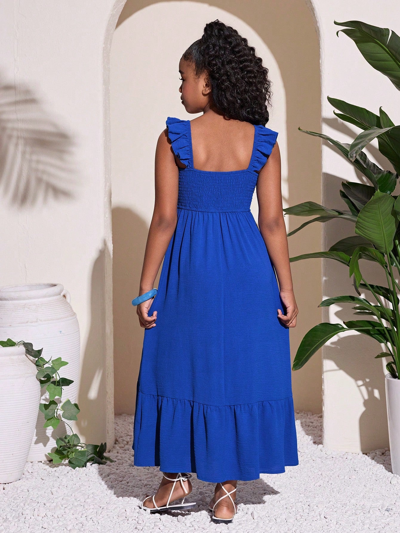 Tween girls A-line vacation dress with square neck, shirred cinched waist, ruffle details, zipper closure, and flounce hem.