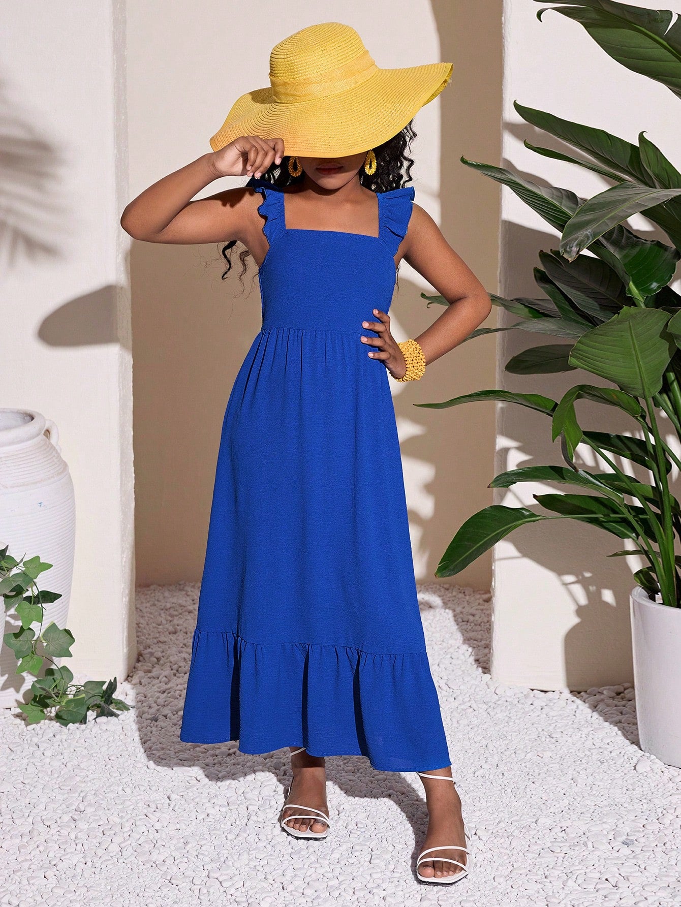 Tween girls A-line vacation dress with square neck, shirred cinched waist, ruffle details, zipper closure, and flounce hem.