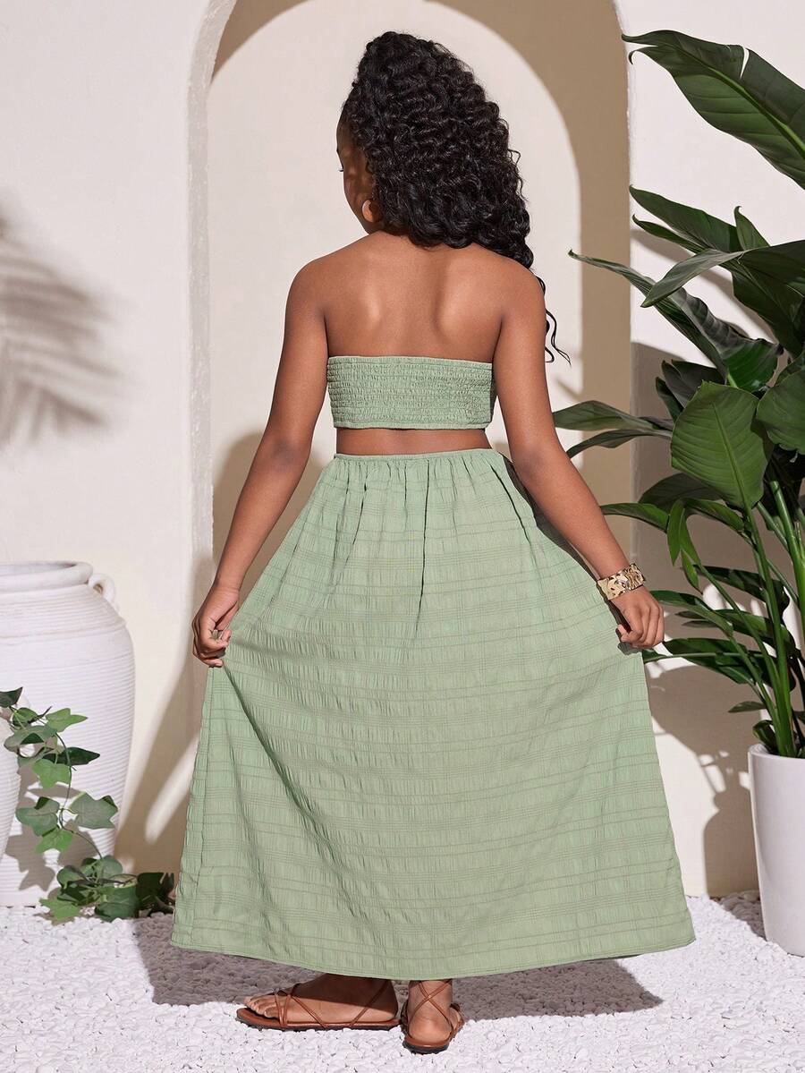 Tween girl yellow long halter dress with cutout waist, split detail, shirred textured fabric, sleeveless design, high waist, and flared hem for beach vacation wear.