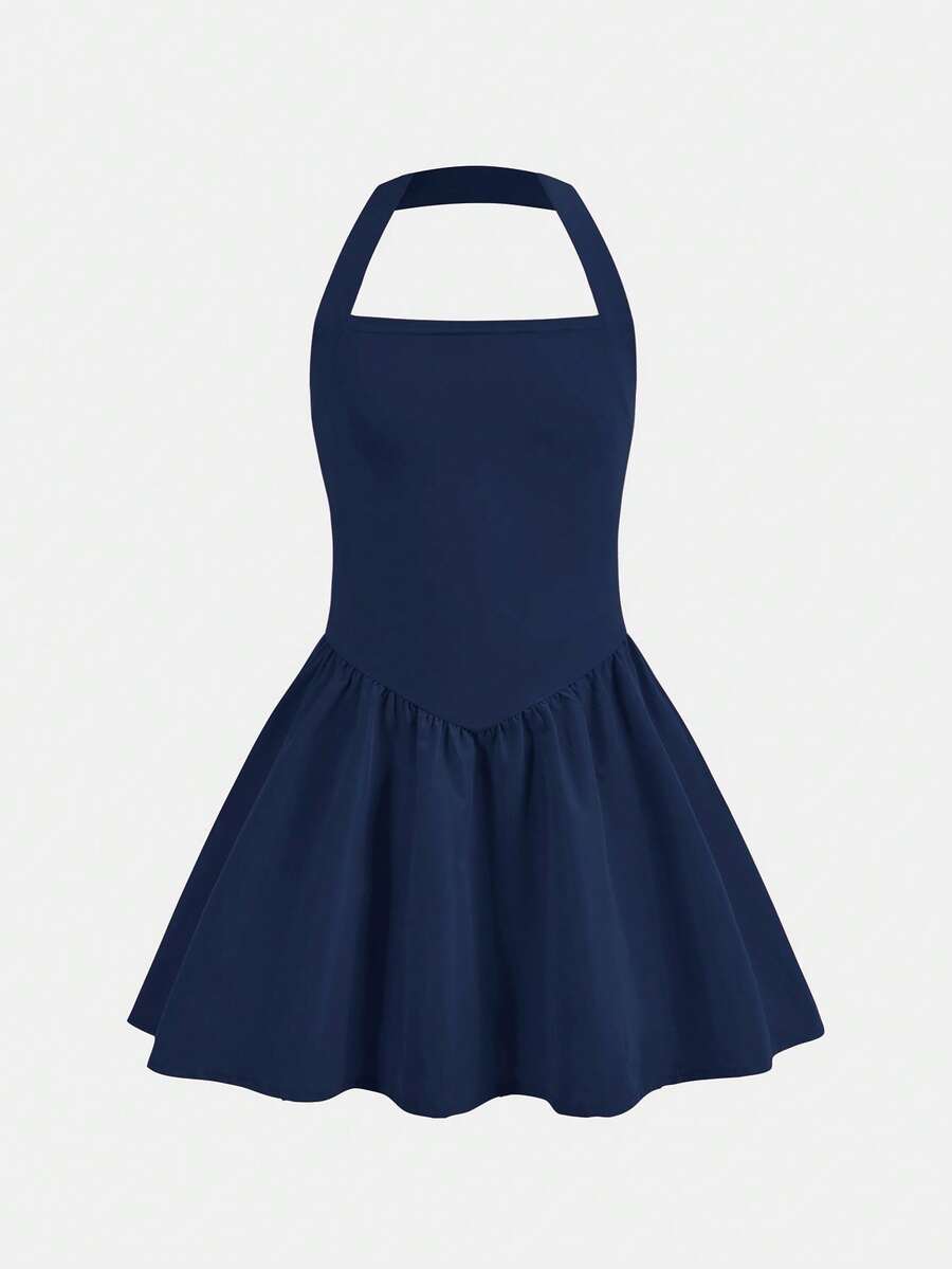 Black sleeveless halter polka dot mini dress for tween girls featuring a high waist and flared hem