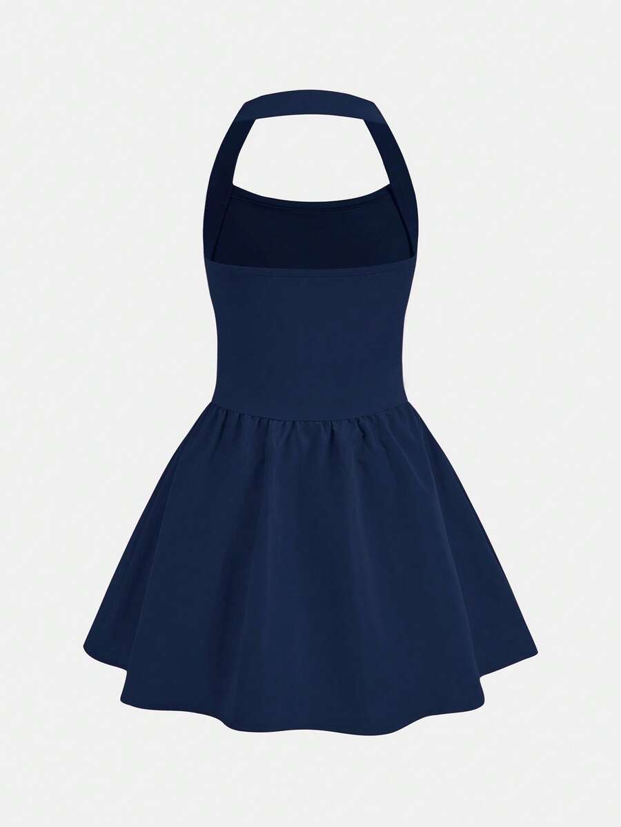 Black sleeveless halter polka dot mini dress for tween girls featuring a high waist and flared hem