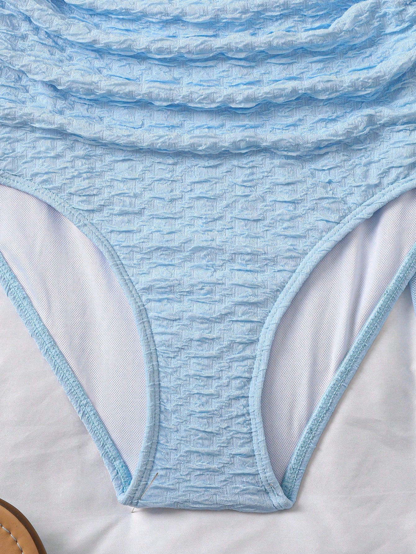 Baby blue tween girls one-piece swimsuit with textured metallic starfish decor, spaghetti straps, ruched fitted body, and short apron-style skirt cover-up