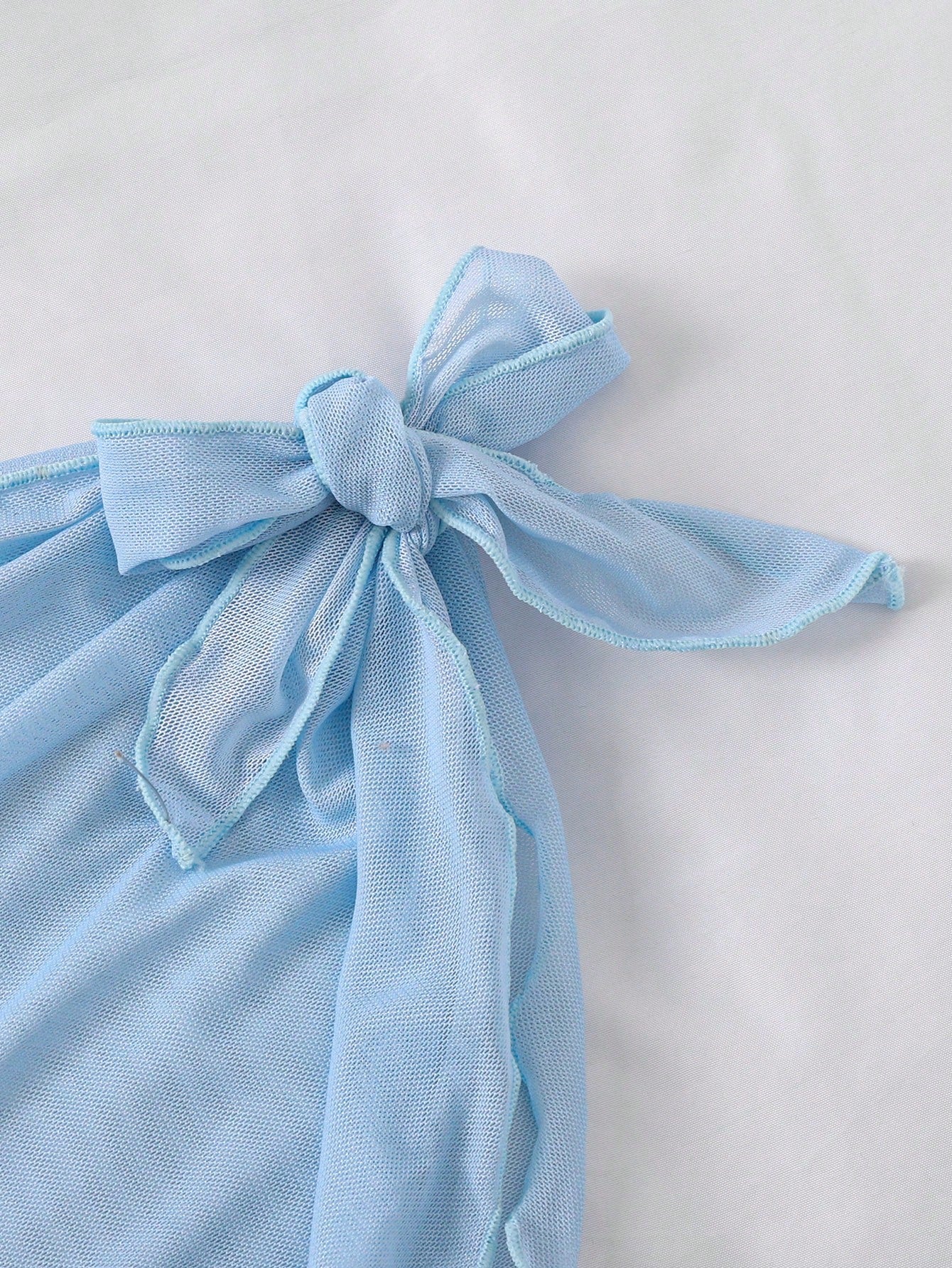Baby blue tween girls one-piece swimsuit with textured metallic starfish decor, spaghetti straps, ruched fitted body, and short apron-style skirt cover-up