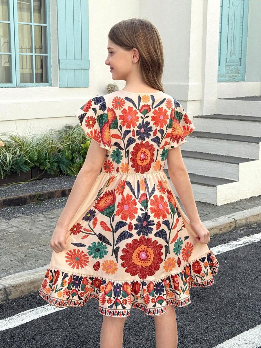 Tween girl wearing a black ditsy floral A-line short dress with V-neckline and flounce short sleeves.